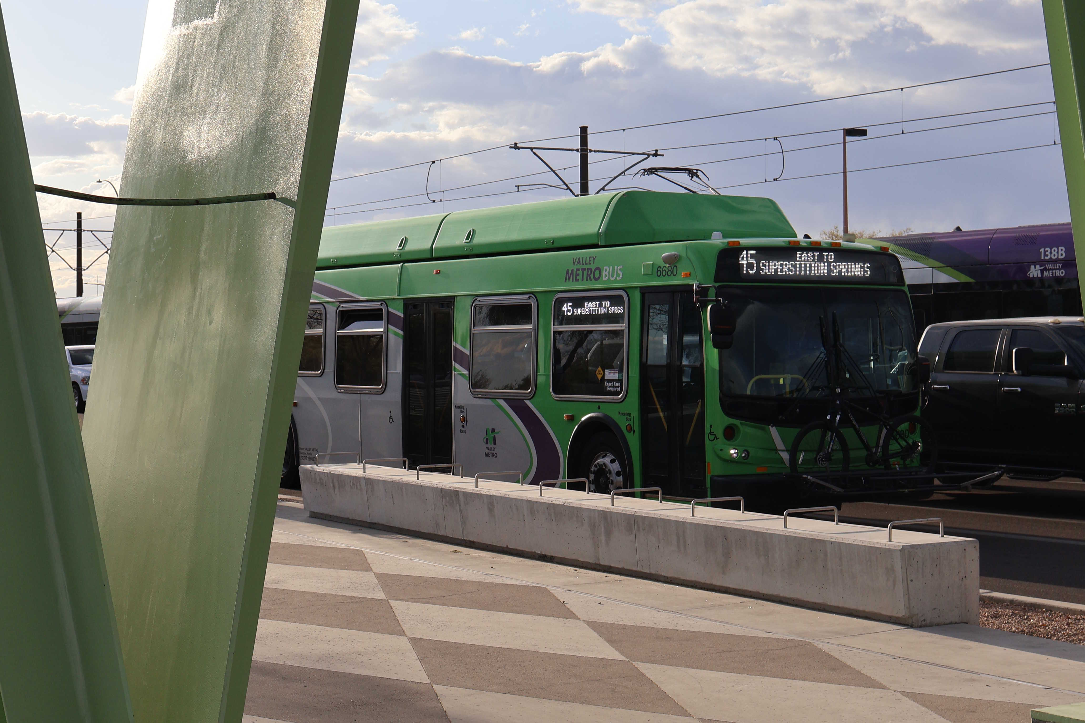 A gray and green Valley Metro bus, number 6680, traveling eastbound on Main Street in Mesa on route 45 to Superstition Springs Transit Center