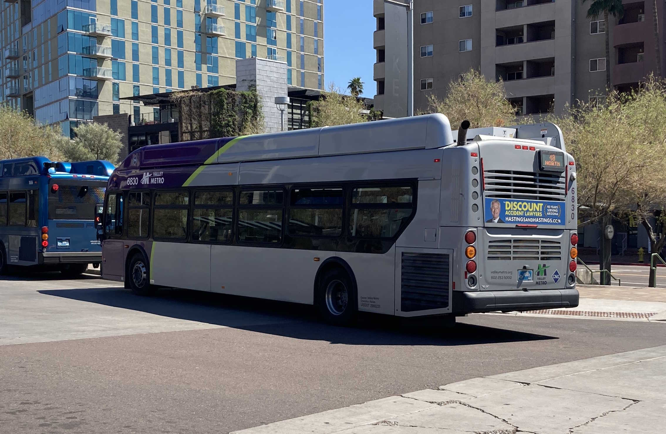 A gray, green, and purple Valley Metro bus, number 6830, at the Tempe Transportation Center, traveling route 48 to Mesa Riverview