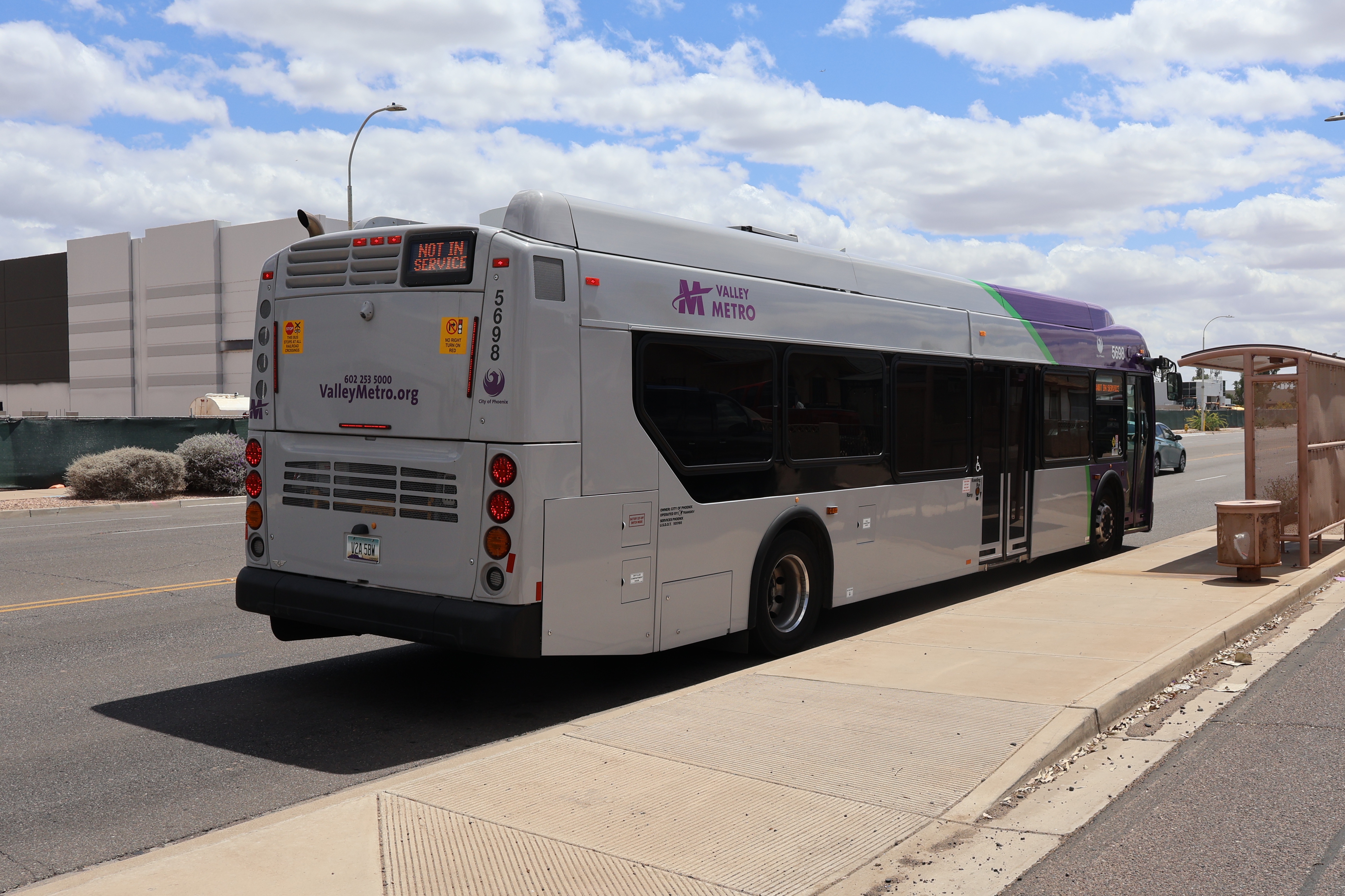 A purple and gray Valley Metro bus, number 5698, traveling southbound on 48th Street in Phoenix on route 52 to 48th Street and Roeser Road