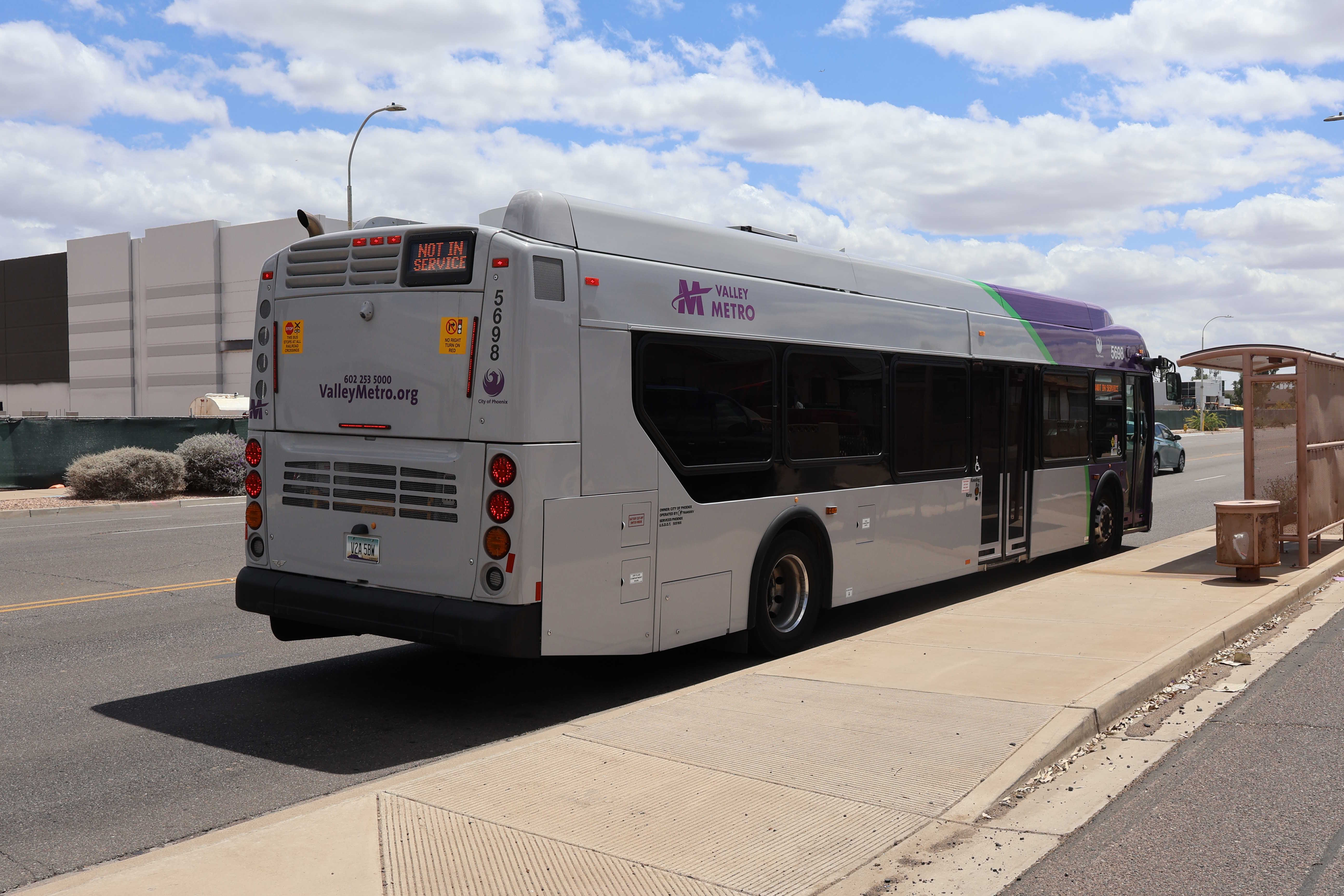 A purple and gray Valley Metro bus, number 5698, traveling southbound on 48th Street in Phoenix on route 52 to 48th Street and Roeser Road
