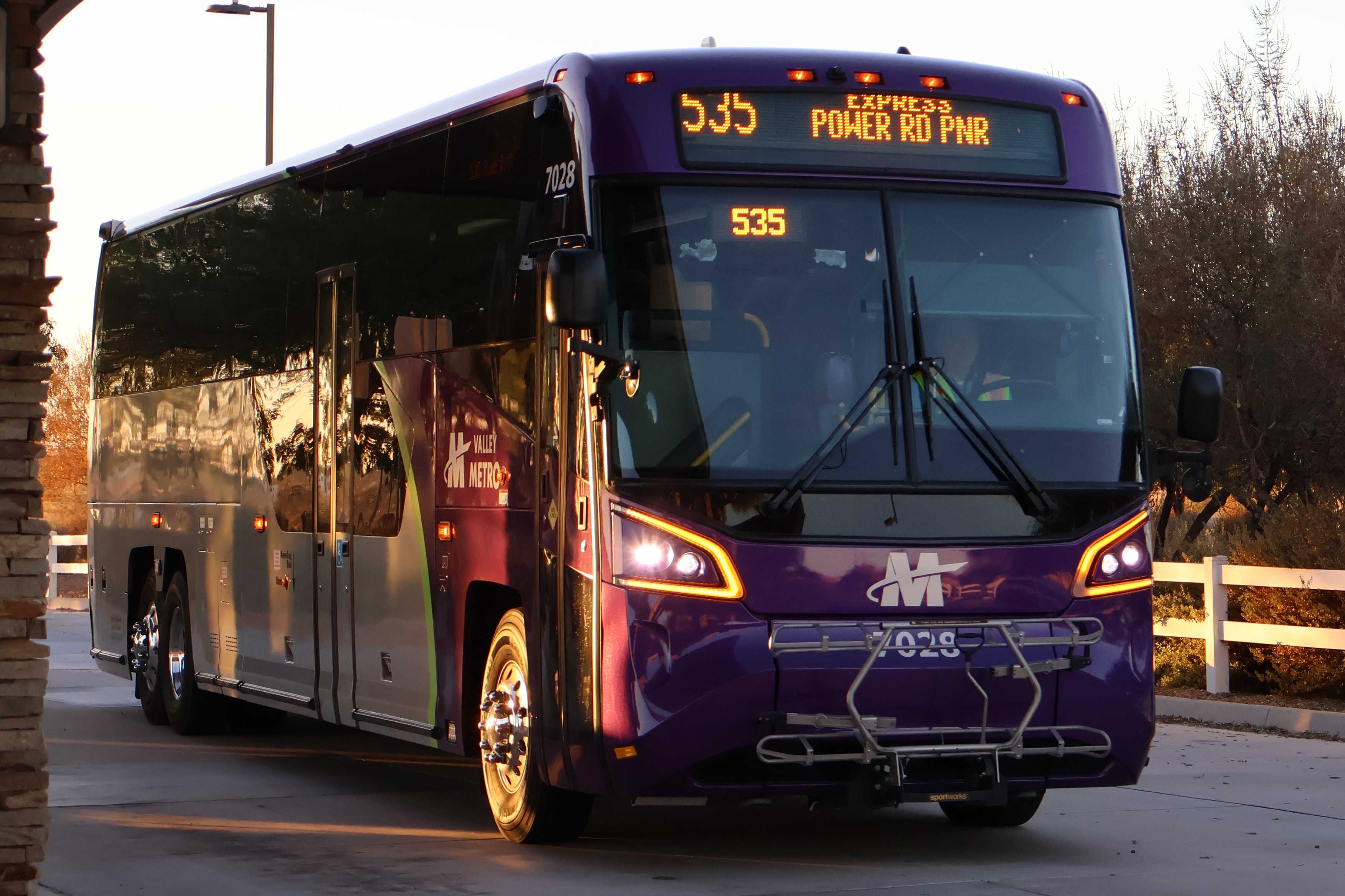 A gray and purple Valley Metro bus, with a green stripe, number 7028, at Gilbert Road and McDowell Road Park and Ride in Mesa on route 535 to Power Road Park and Ride