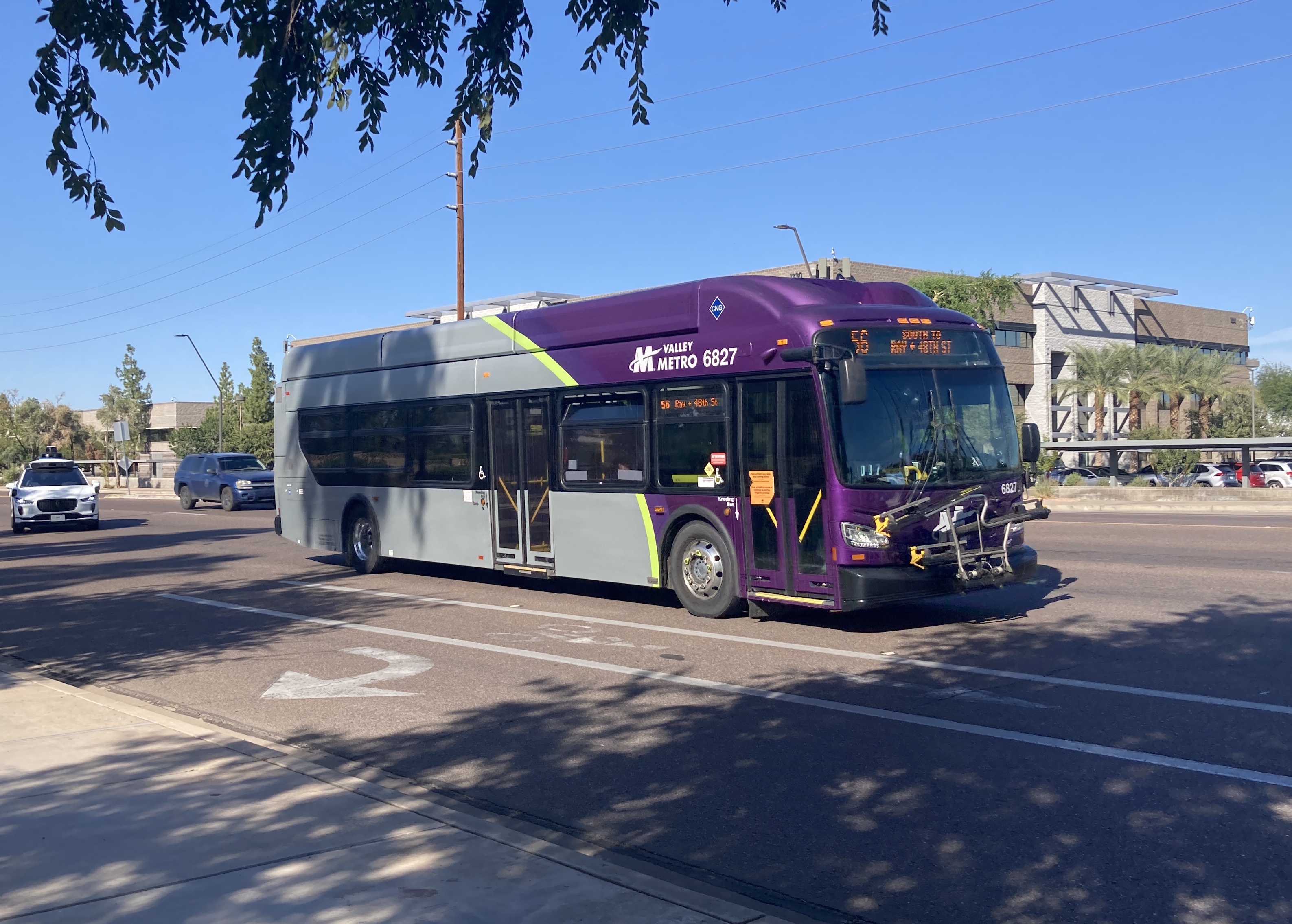 A gray and purple Valley Metro bus with a green stripe, number 6827, traveling southbound on Priest Drive in Tempe on route 56 to Ray Road & 48th Street