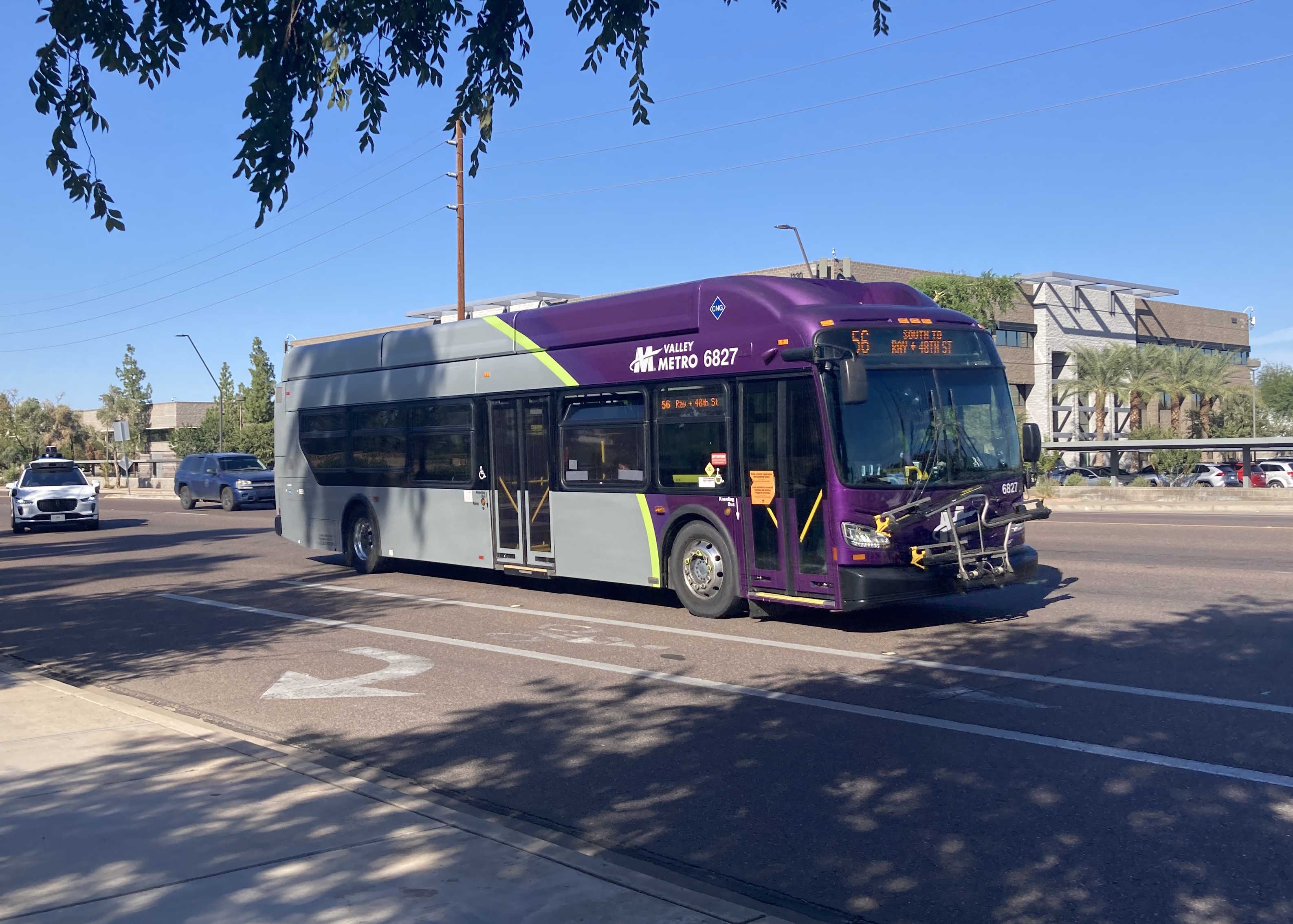 A gray and purple Valley Metro bus with a green stripe, number 6827, traveling southbound on Priest Drive on route 56 to Ray Road & 48th Street