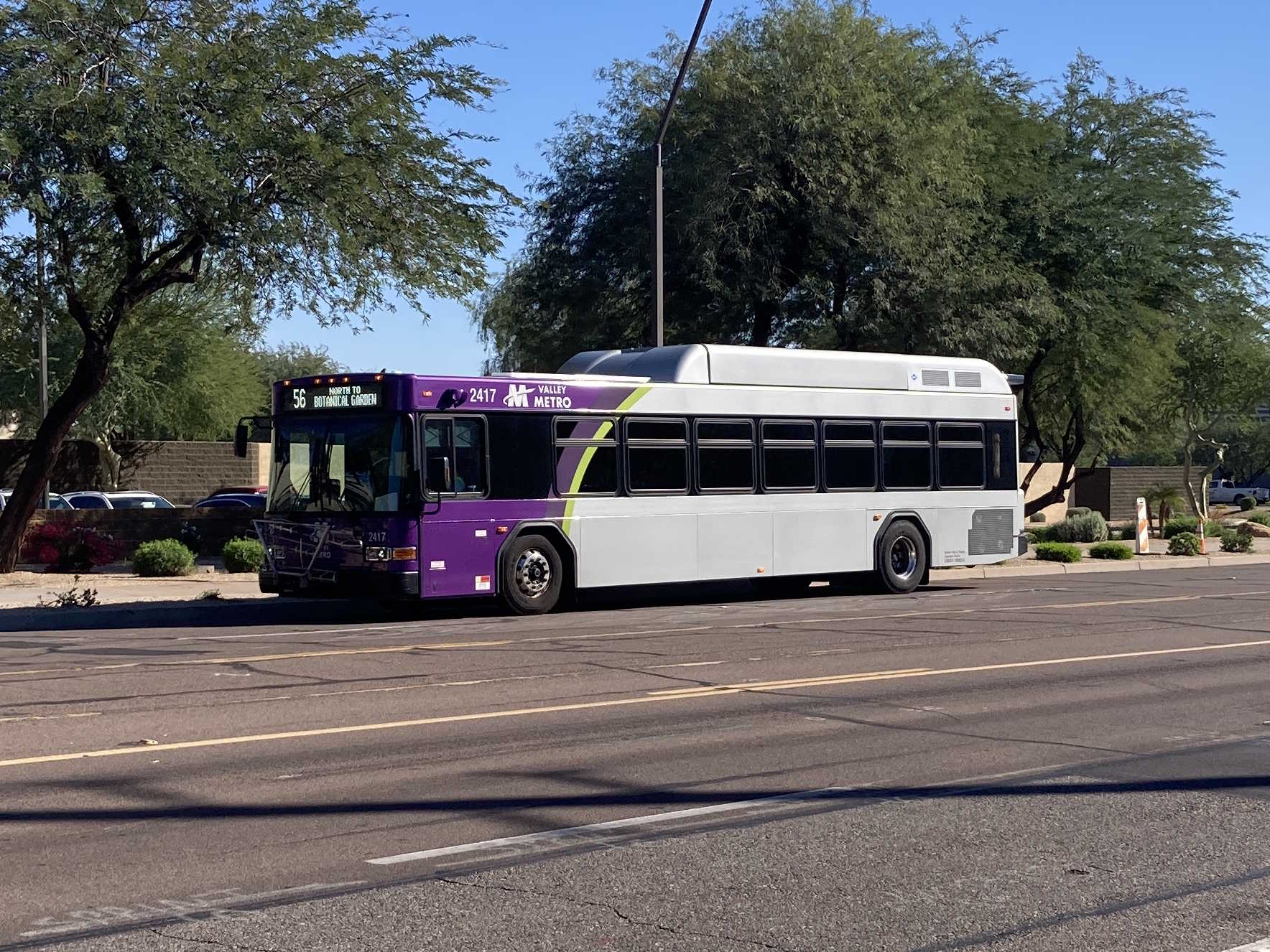 A gray and purple Valley Metro bus, with a green stripe, number 2417, traveling northbound on Priest Drive in Tempe on route 56 to the Desert Botanical Garden