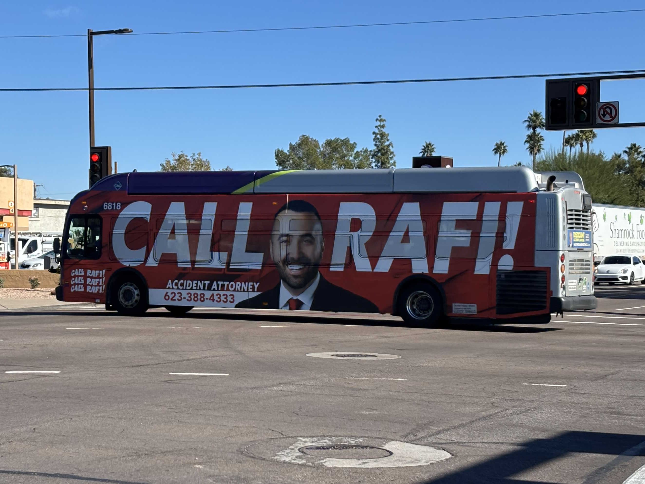 A gray and purple Valley Metro bus with a green stripe, number 6818, traveling northbound on Priest Drive on route 56 to the Desert Botanical Garden