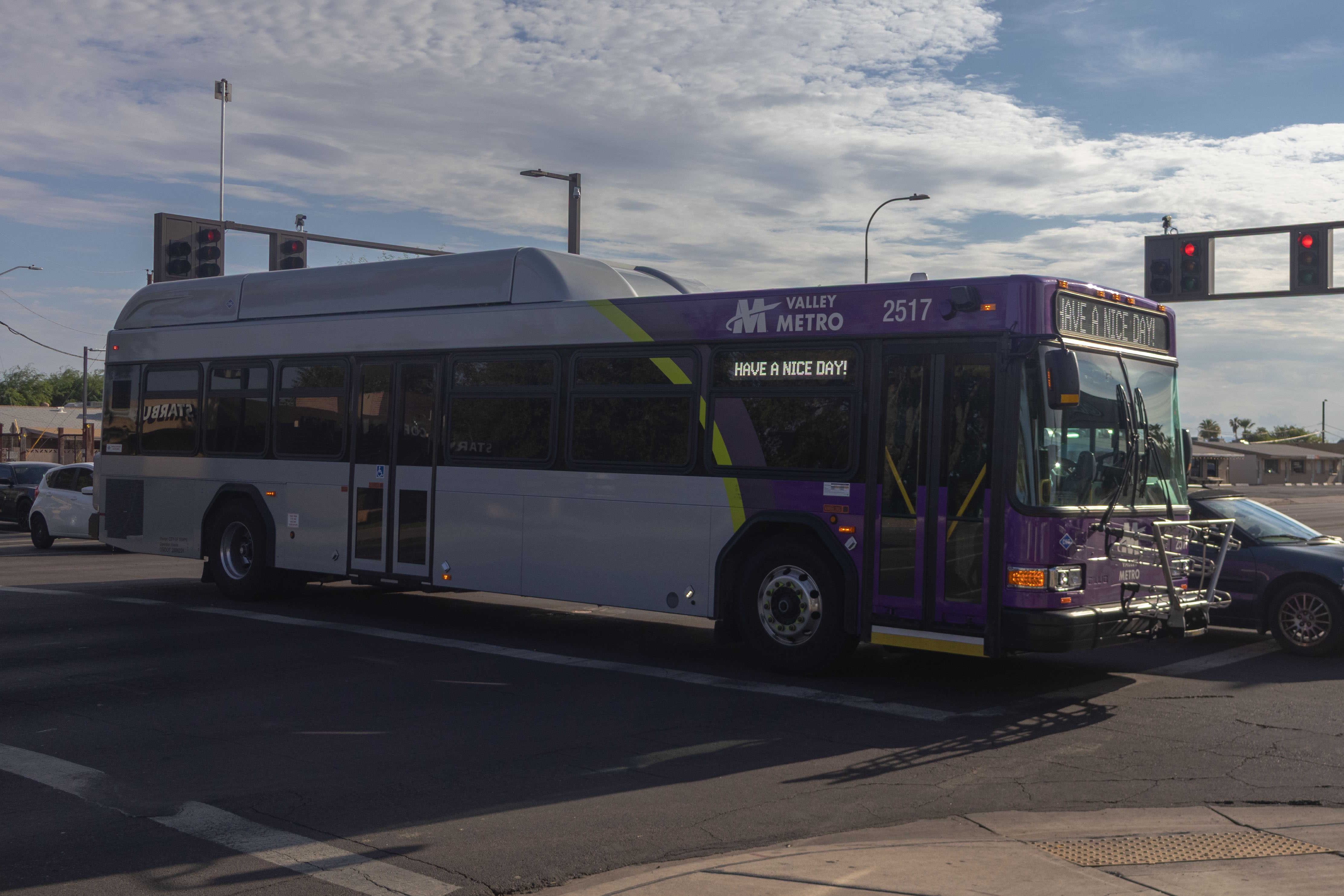 A gray and purple Valley Metro bus, with a green stripe, number 2517, traveling northbound on Hardy Drive on route 62 to Tempe Marketplace
