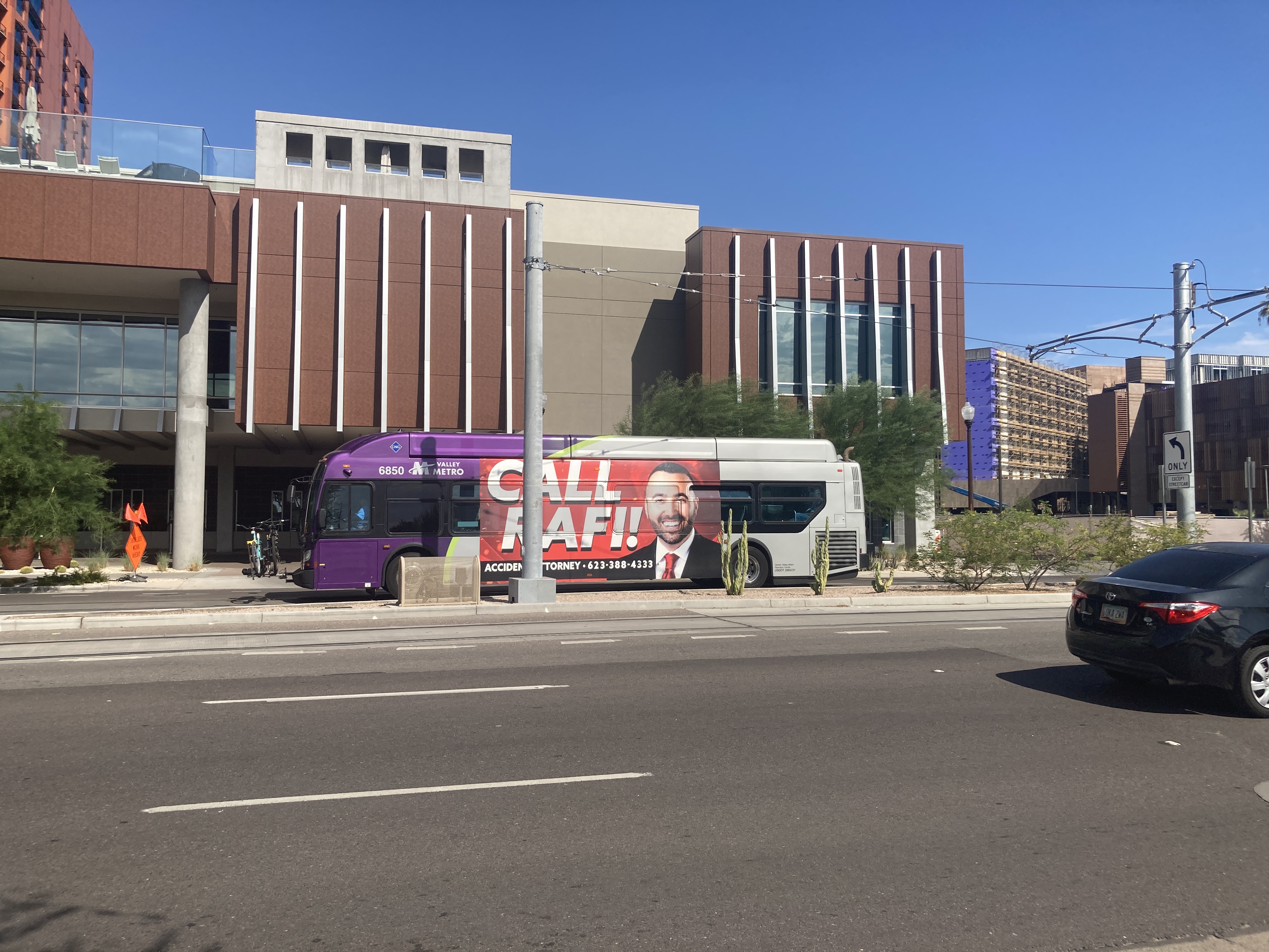 A gray, green, and purple Valley Metro bus, number 6850, traveling northbound on Mill Avenue in Tempe on route 66 to Downtown Tempe / ASU