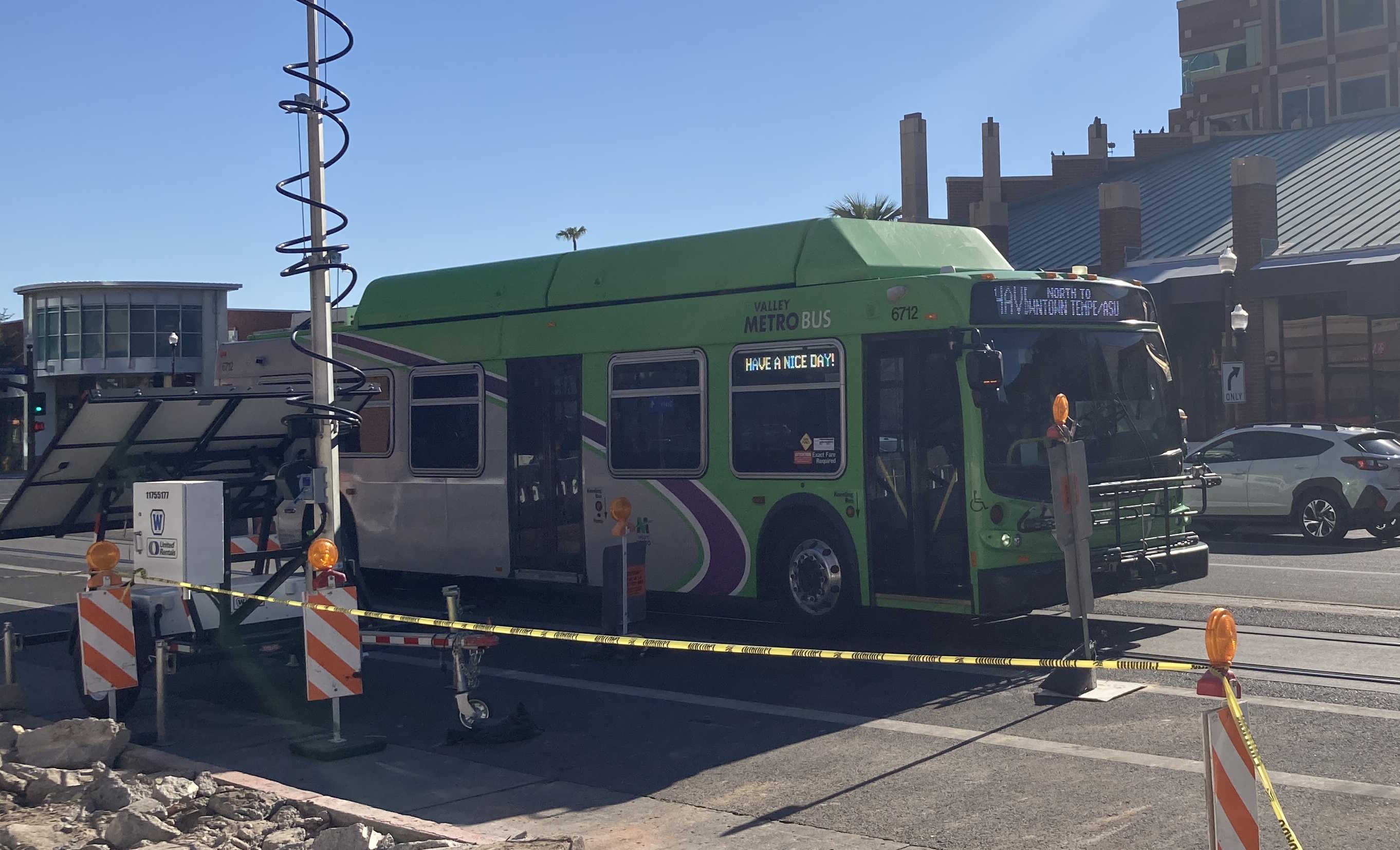 A green Valley Metro bus with a purple and white stripe, number 6712, traveling northbound on Mill Avenue in Tempe on route 66 to Downtown Tempe / ASU