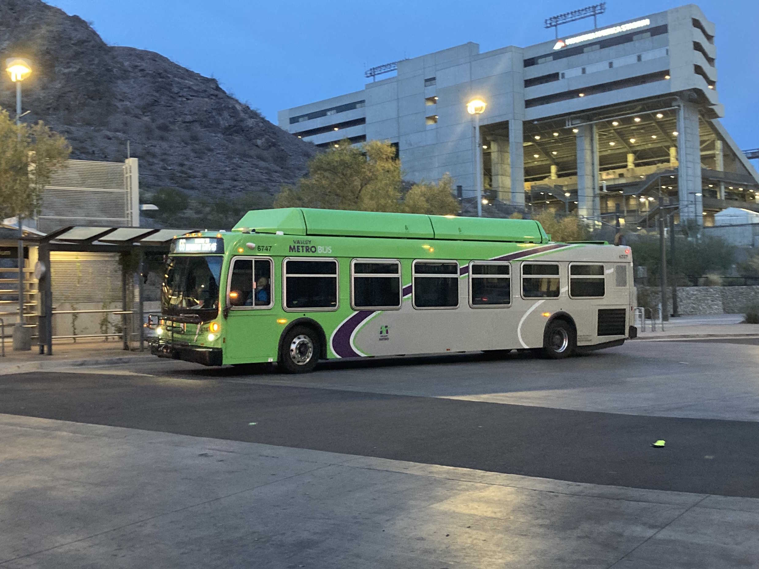 A green Valley Metro bus with a purple and white stripe, number 6747, at the Tempe Transportation Center on route 66 to Downtown Tempe / ASU