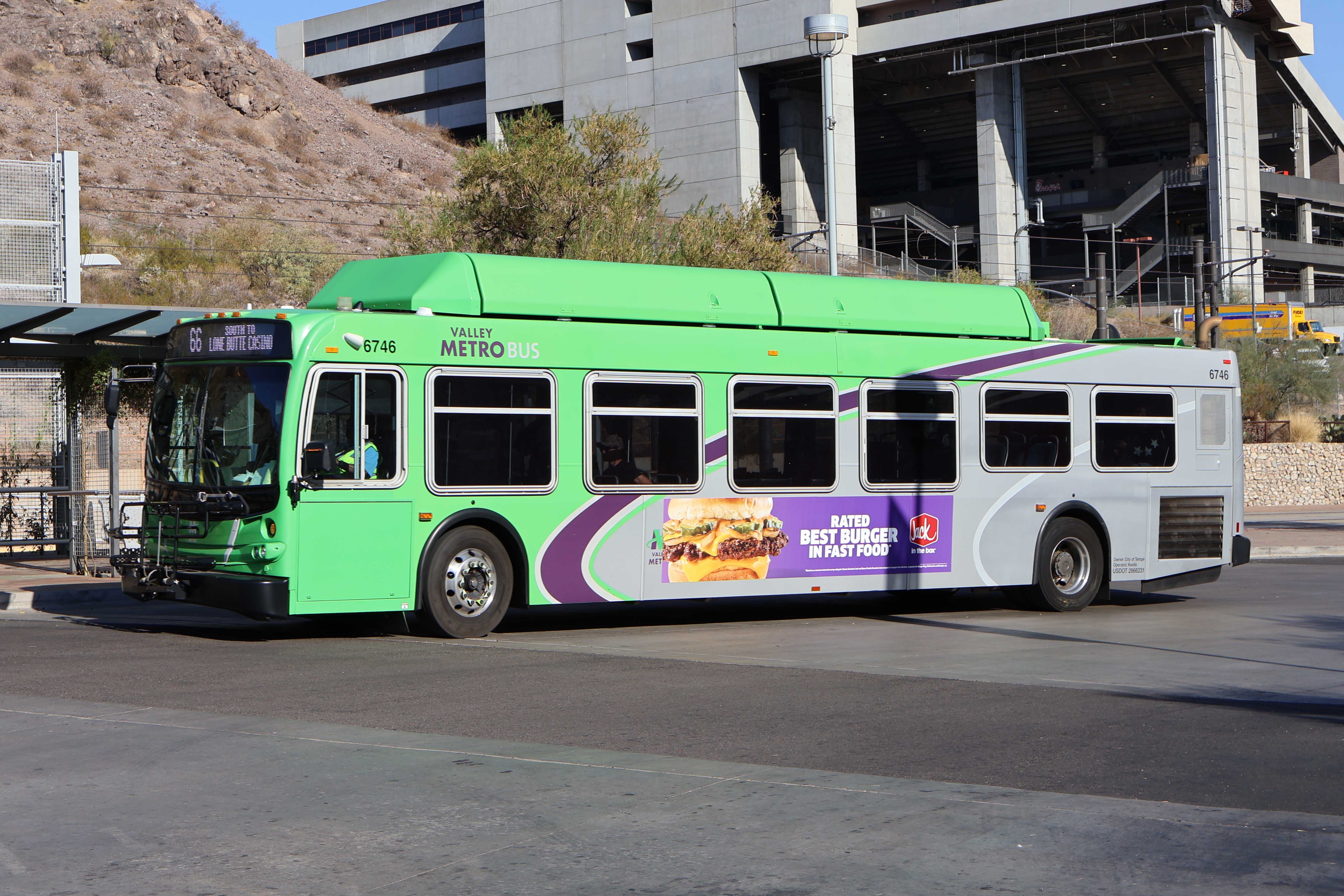 A green Valley Metro bus with a purple and white stripe, number 6746, at the Tempe Transportation Center on route 66 to Lone Butte Casino