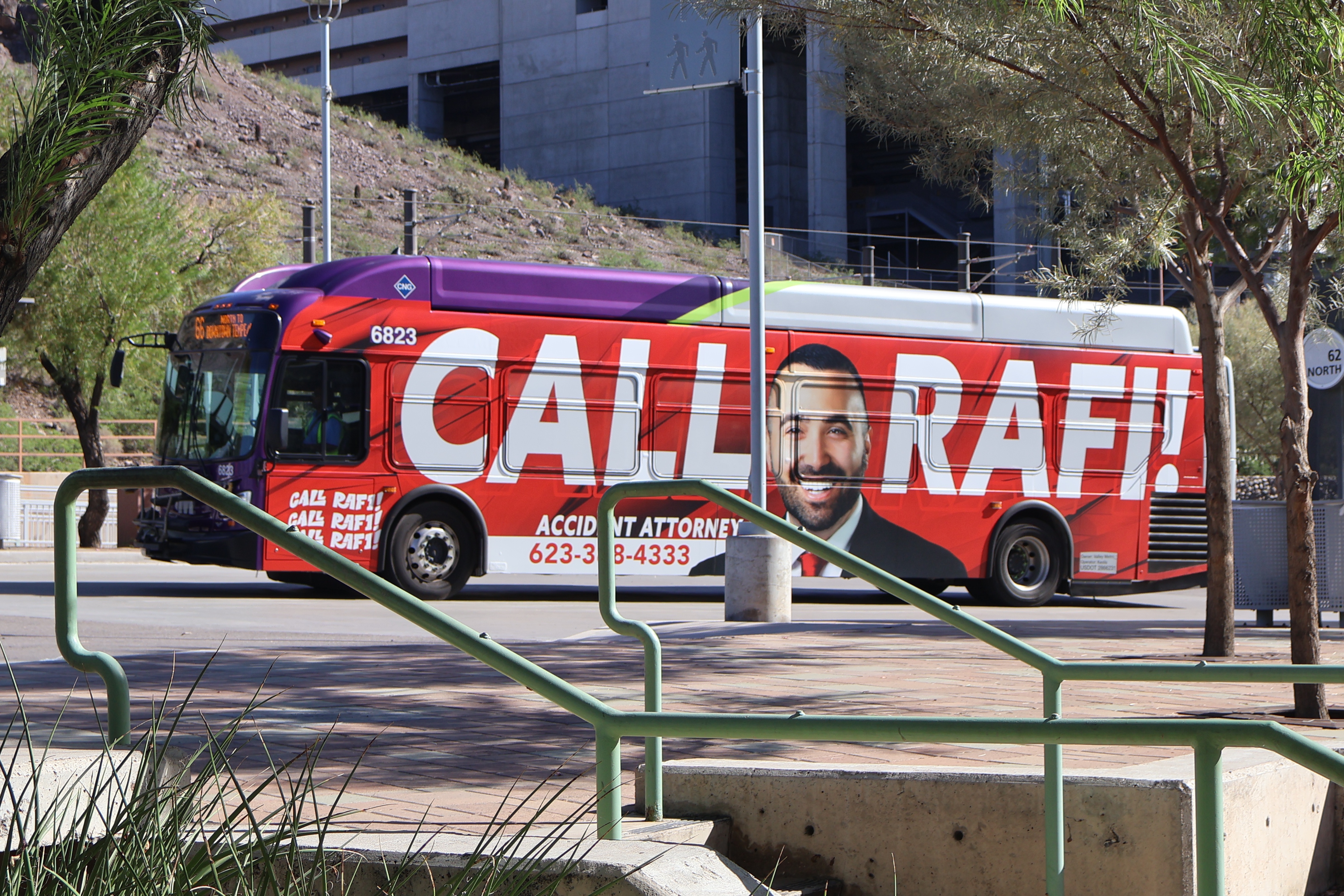 A gray and purple Valley Metro bus, with a green stripe, number 6823, at the Tempe Transportation Center on route 66 to Downtown Tempe / ASU