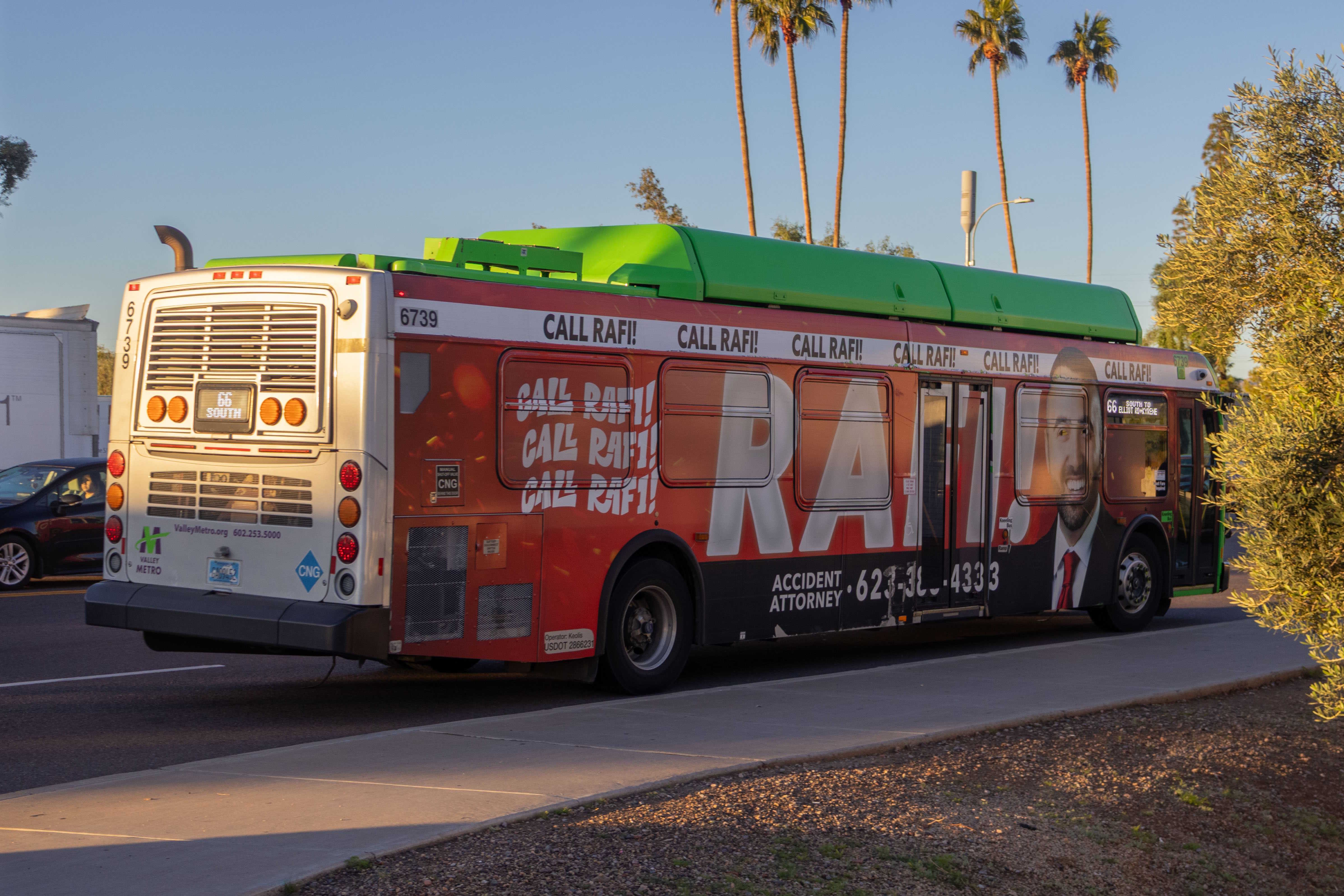 A green Valley Metro bus with a purple and white stripe, number 6739, traveling westbound on Baseline Road in Tempe on route 66 to Kyrene Road and Elliot Road