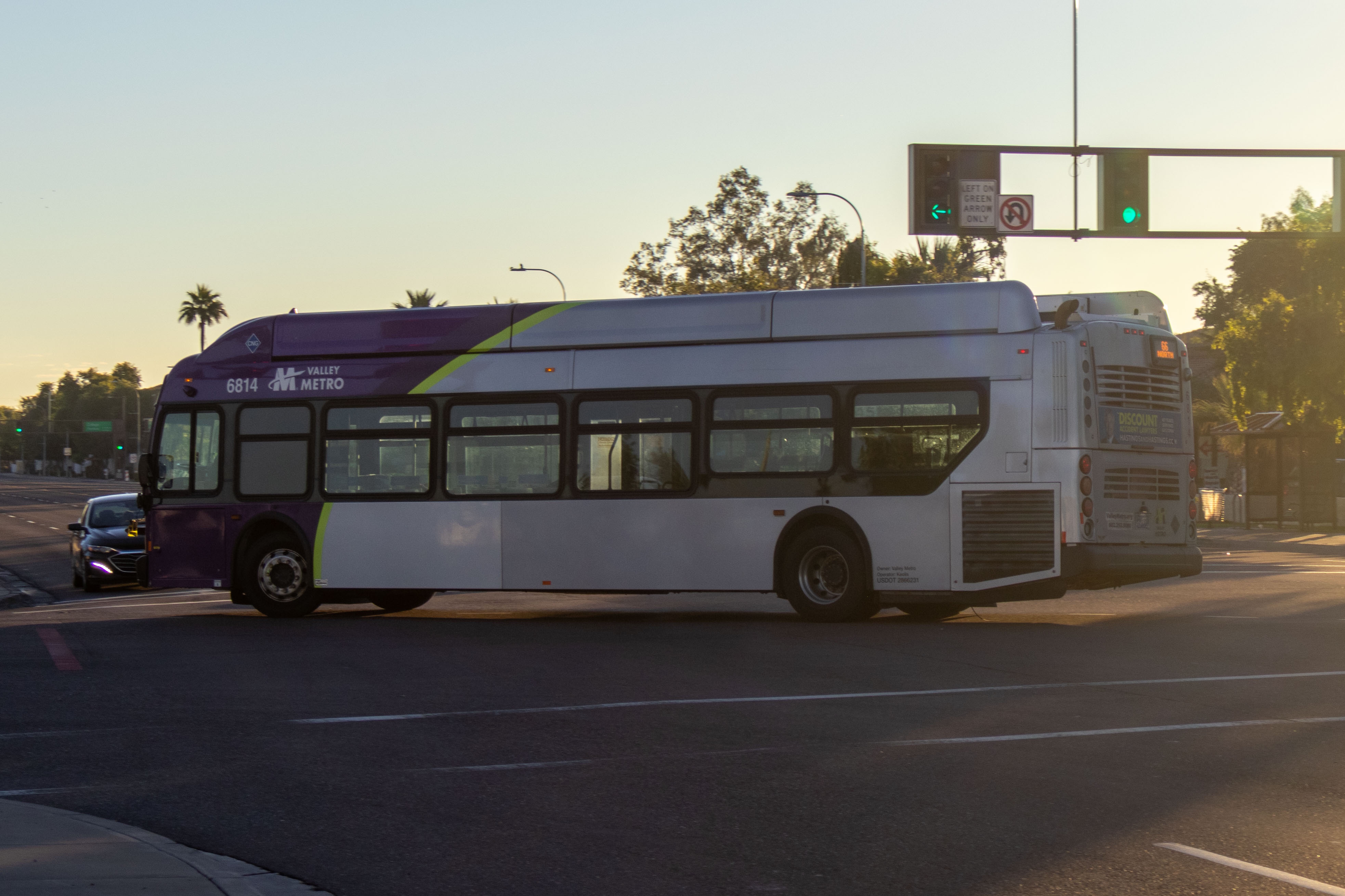 A gray and purple Valley Metro bus, with a green stripe, number 6814, traveling northbound on Mill Avenue in Tempe on route 66 to Downtown Tempe / ASU