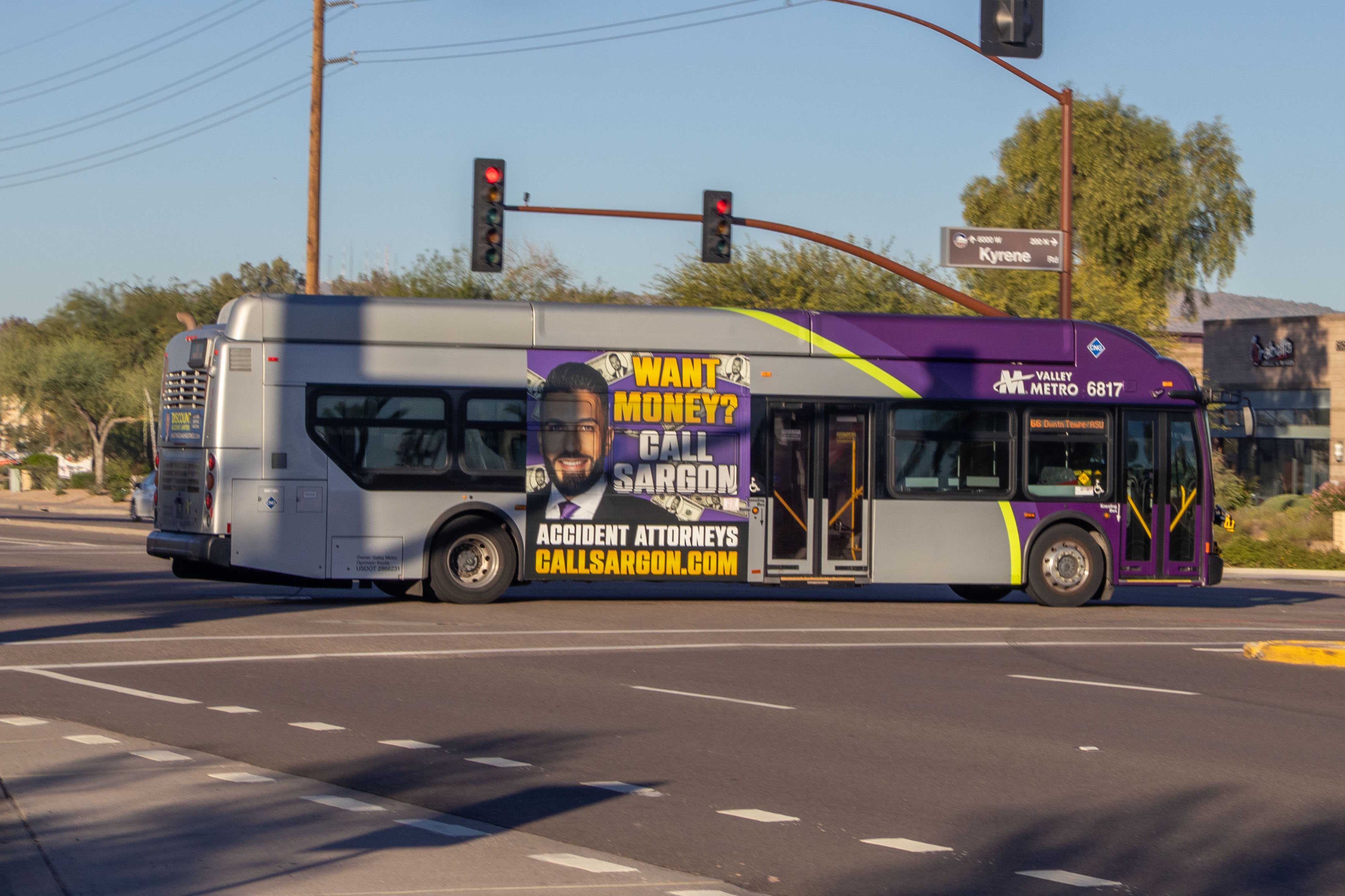 A gray and purple Valley Metro bus, with a green stripe, number 6817, traveling northbound on Kyrene Road in Chandler on route 66 to Downtown Tempe / ASU