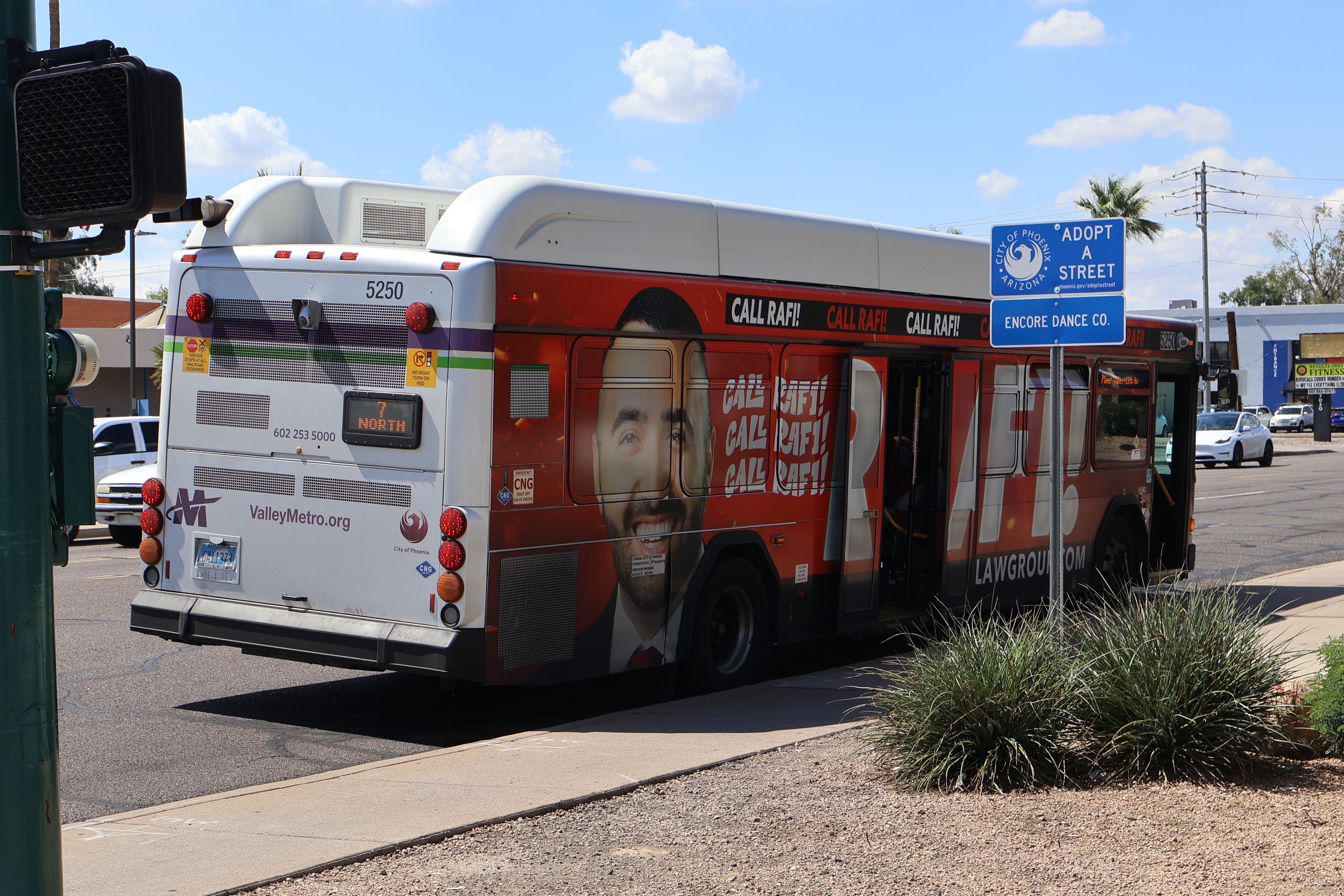 A white and gray Valley Metro bus, with purple and green accent colors, number 5250, traveling northbound on 7th Street in Phoenix on route 7 to Deer Valley Road and 19th Avenue