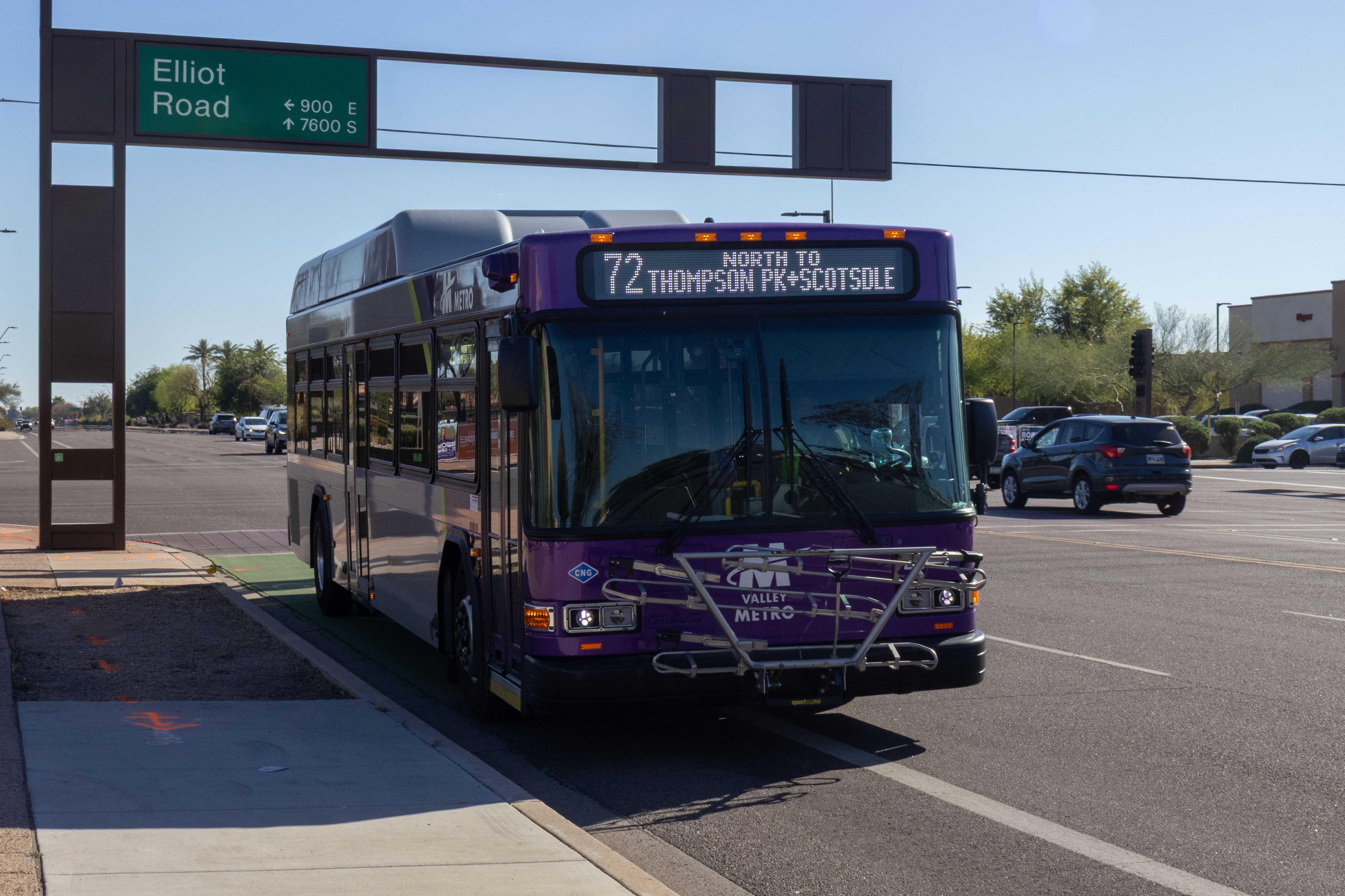 A gray and purple Valley Metro bus, with a green stripe, number 2414, traveling northbound on Rural Road in Tempe on route 72 to Thompson Peak Parkway and Scottsdale Healthcare