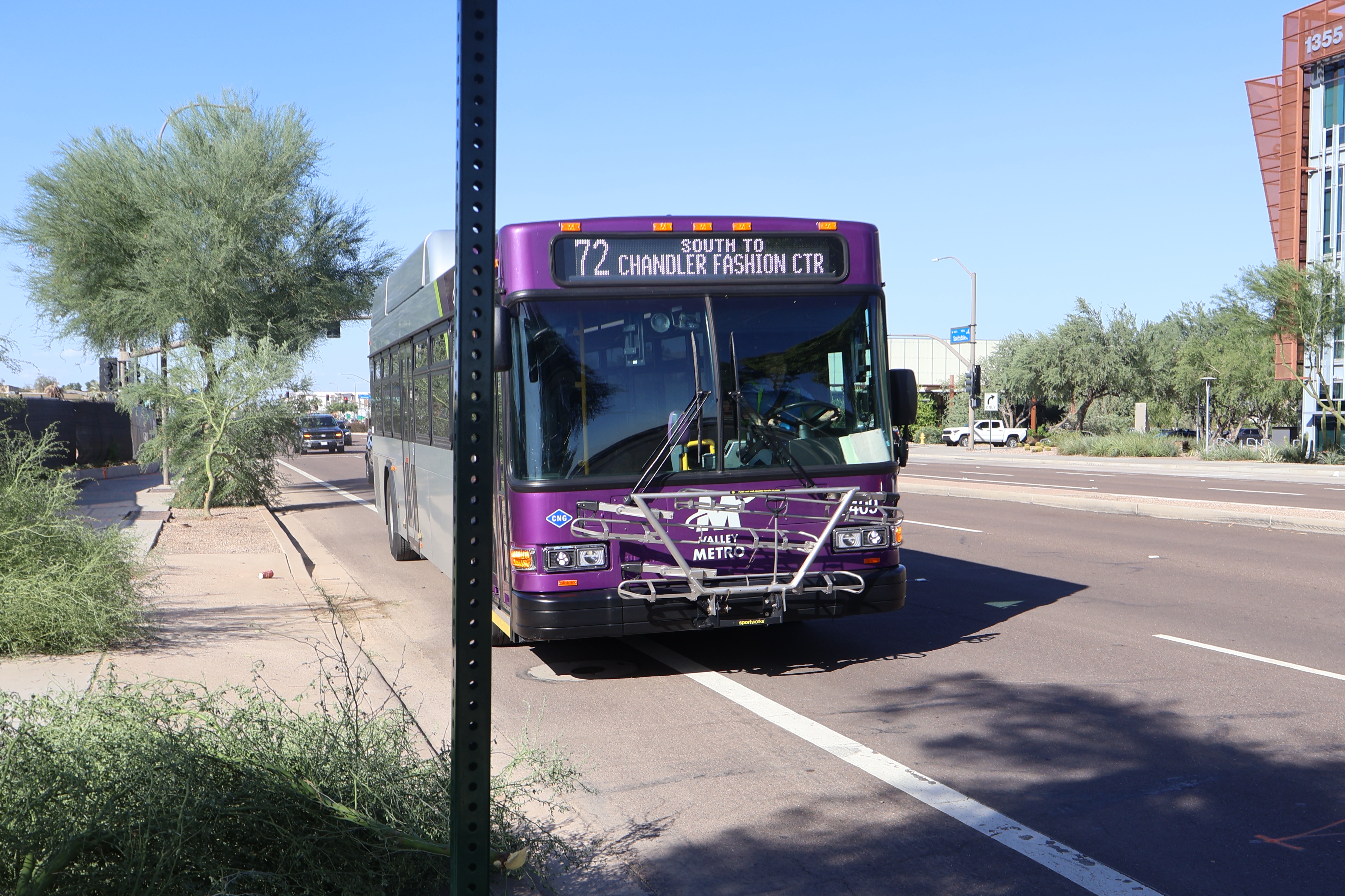 A gray and purple Valley Metro bus, with a green stripe, number 2409, traveling southbound on Scottsdale Road in Scottsdale on route 72 to Chandler Fashion Center