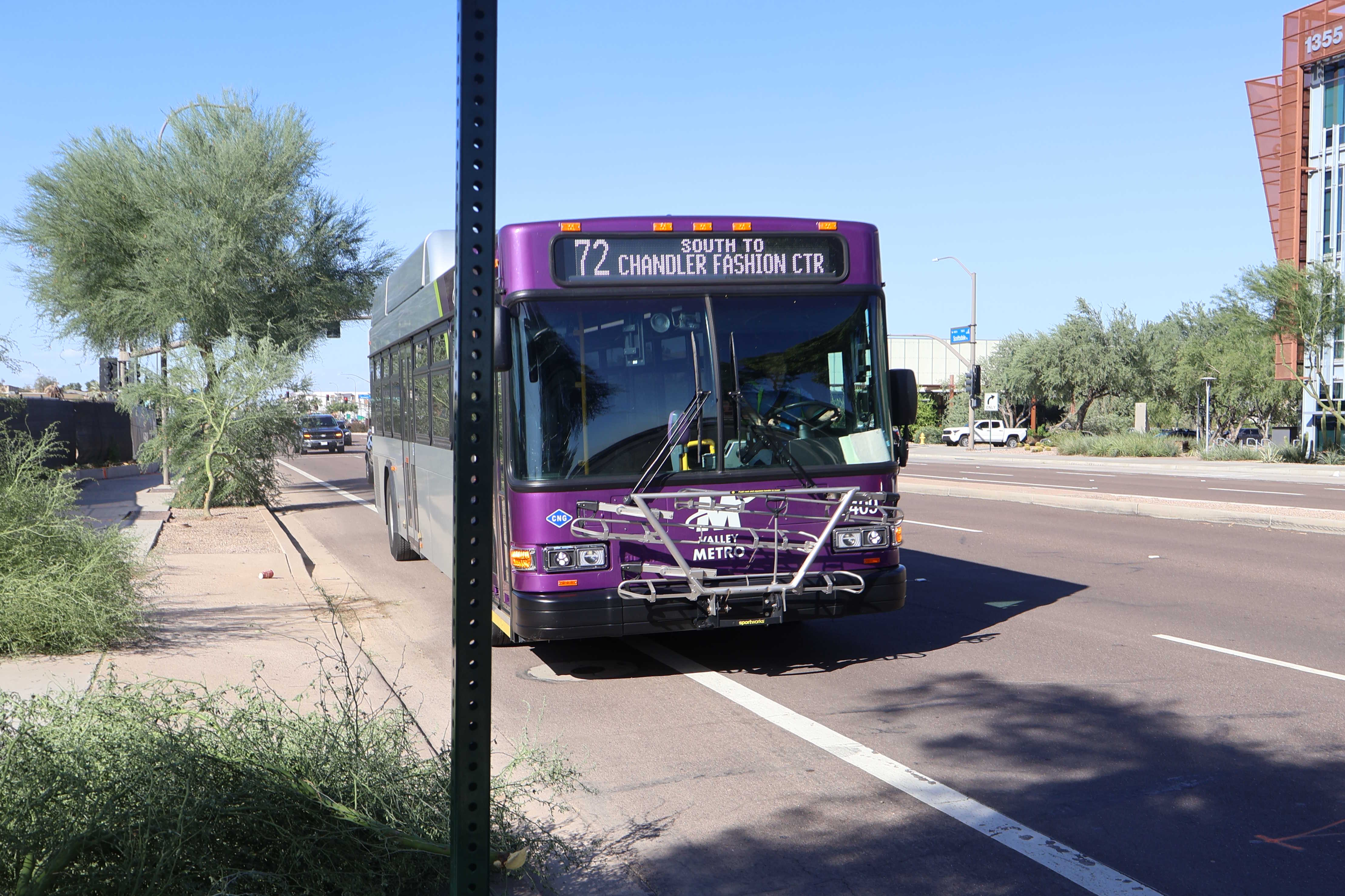 A gray and purple Valley Metro bus, with a green stripe, number 2409, traveling southbound on Scottsdale Road in Scottsdale on route 72 to Chandler Fashion Center