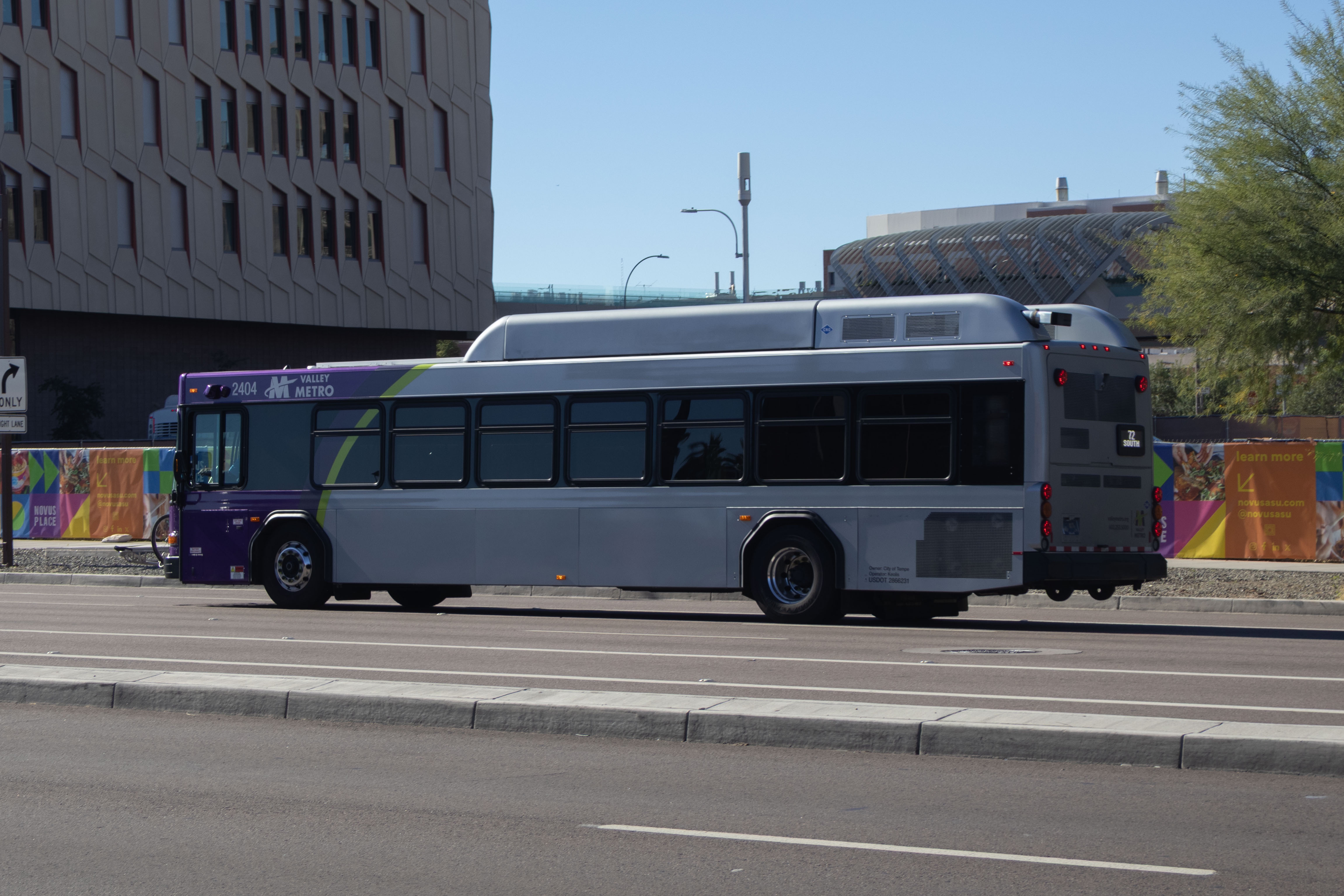 A gray and purple Valley Metro bus, with a green stripe, number 2404, traveling southbound on Rural Road in Tempe on route 72 to Chandler Fashion Center