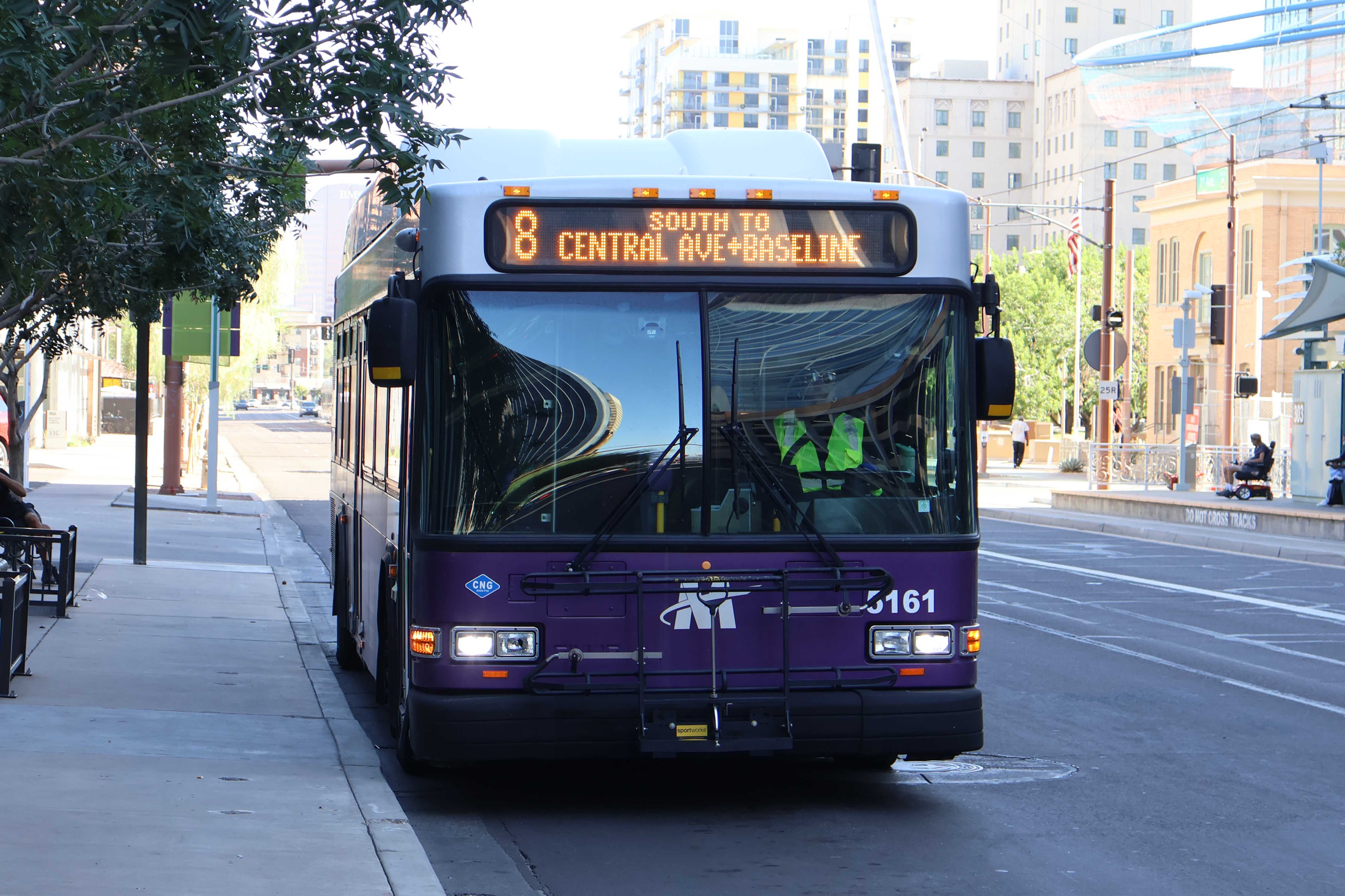 A white and gray Valley Metro bus, with purple and green accent colors, number 5161, traveling southbound on 1st Avenue in Phoenix on route 8 to Baseline Road and Central Avenue
