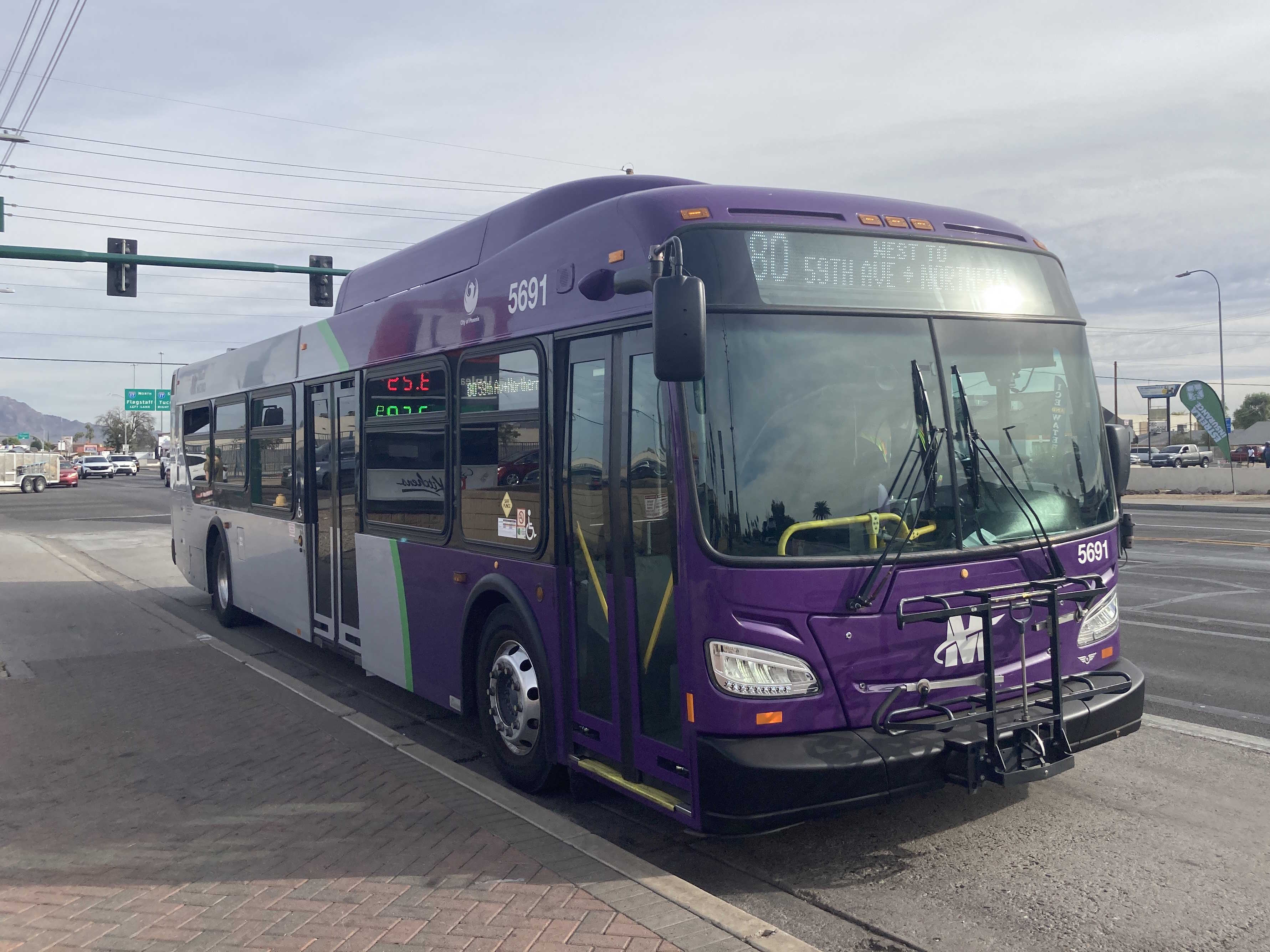 A gray and purple Valley Metro bus, with a green stripe, number 5691, traveling westbound on Northern Avenue in Phoenix on route 80 to Northern Avenue and 59th Avenue