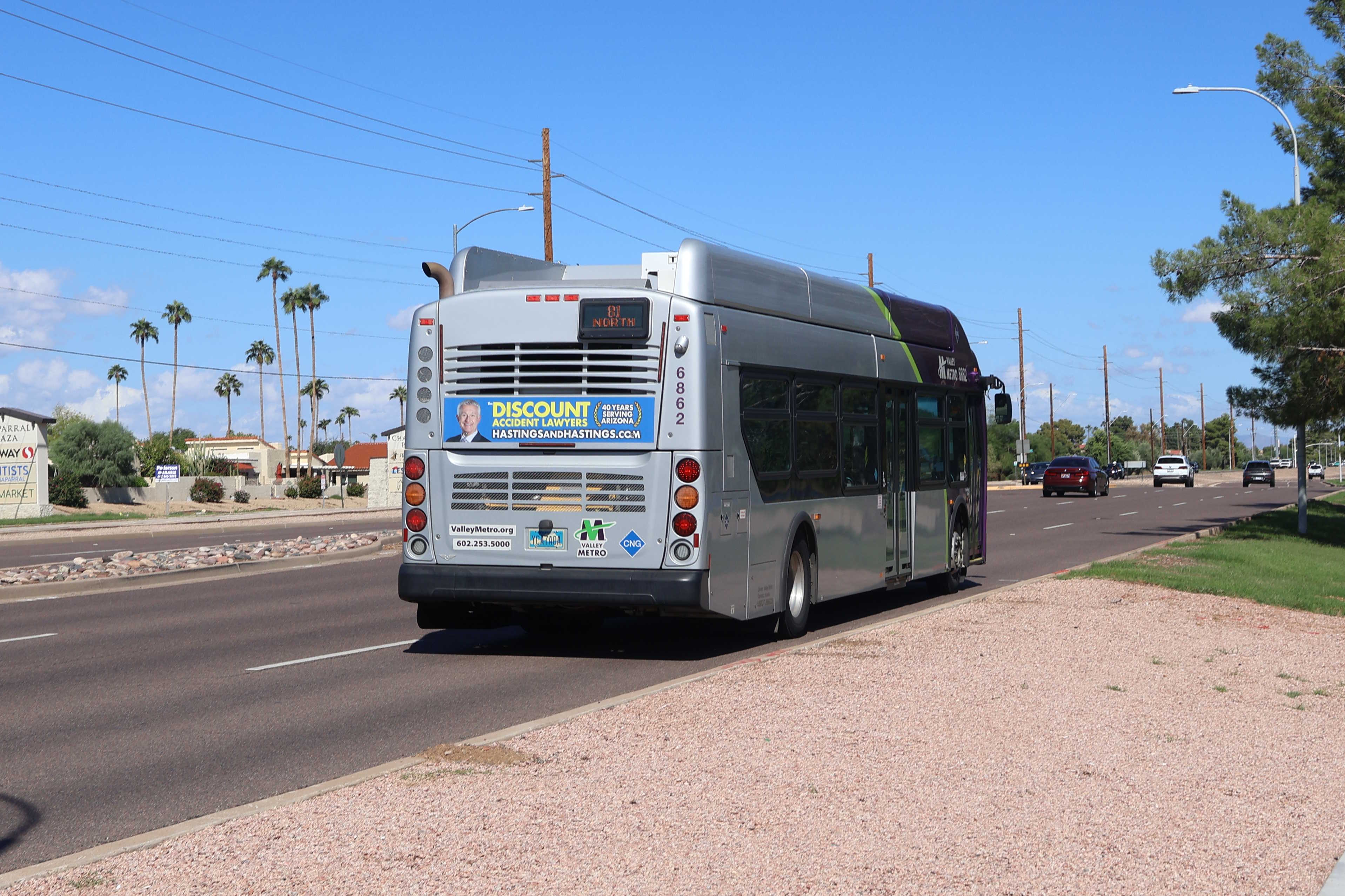 A gray and purple Valley Metro bus with a green stripe, number 6862, traveling northbound on Hayden Road in Scottsdale on route 81 to Mustang Transit Center