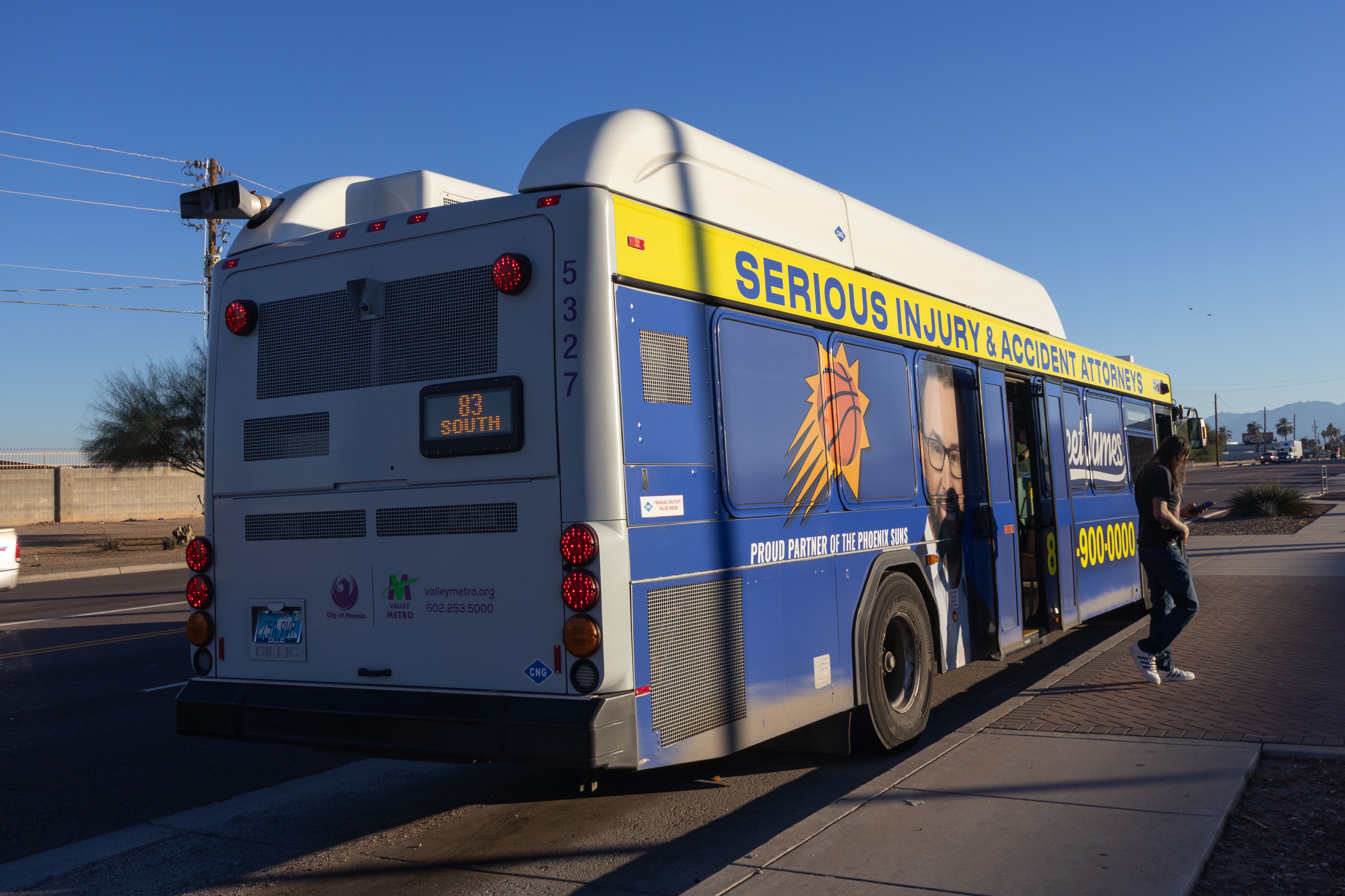 A purple and gray Valley Metro bus, number 5327, traveling southbound on 83rd Avenue in Tolleson on route 83 to 83rd Avenue and Van Buren Street