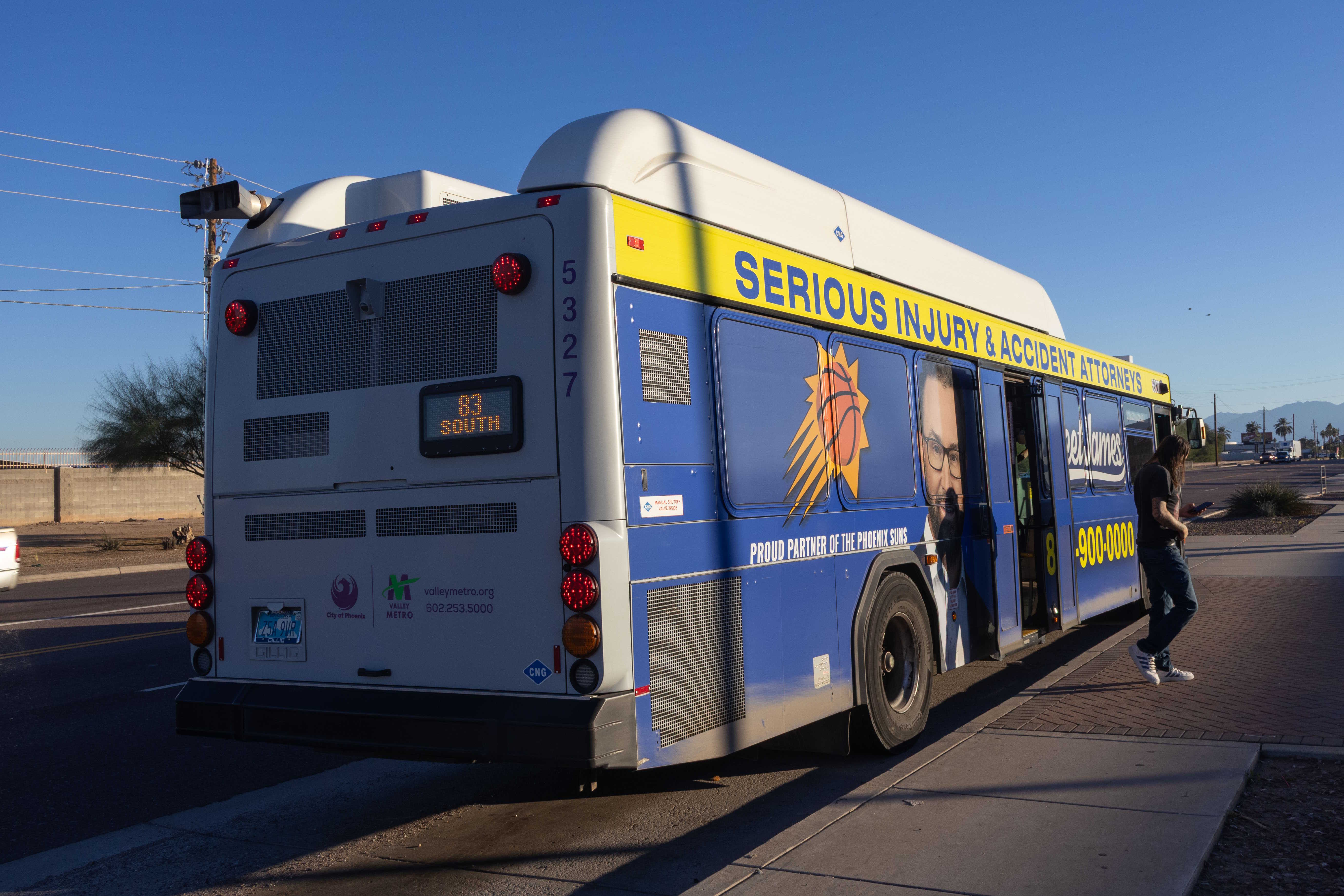 A purple and gray Valley Metro bus, number 5327, traveling southbound on 83rd Avenue in Phoenix on route 83 to 83rd Avenue and Van Buren Street