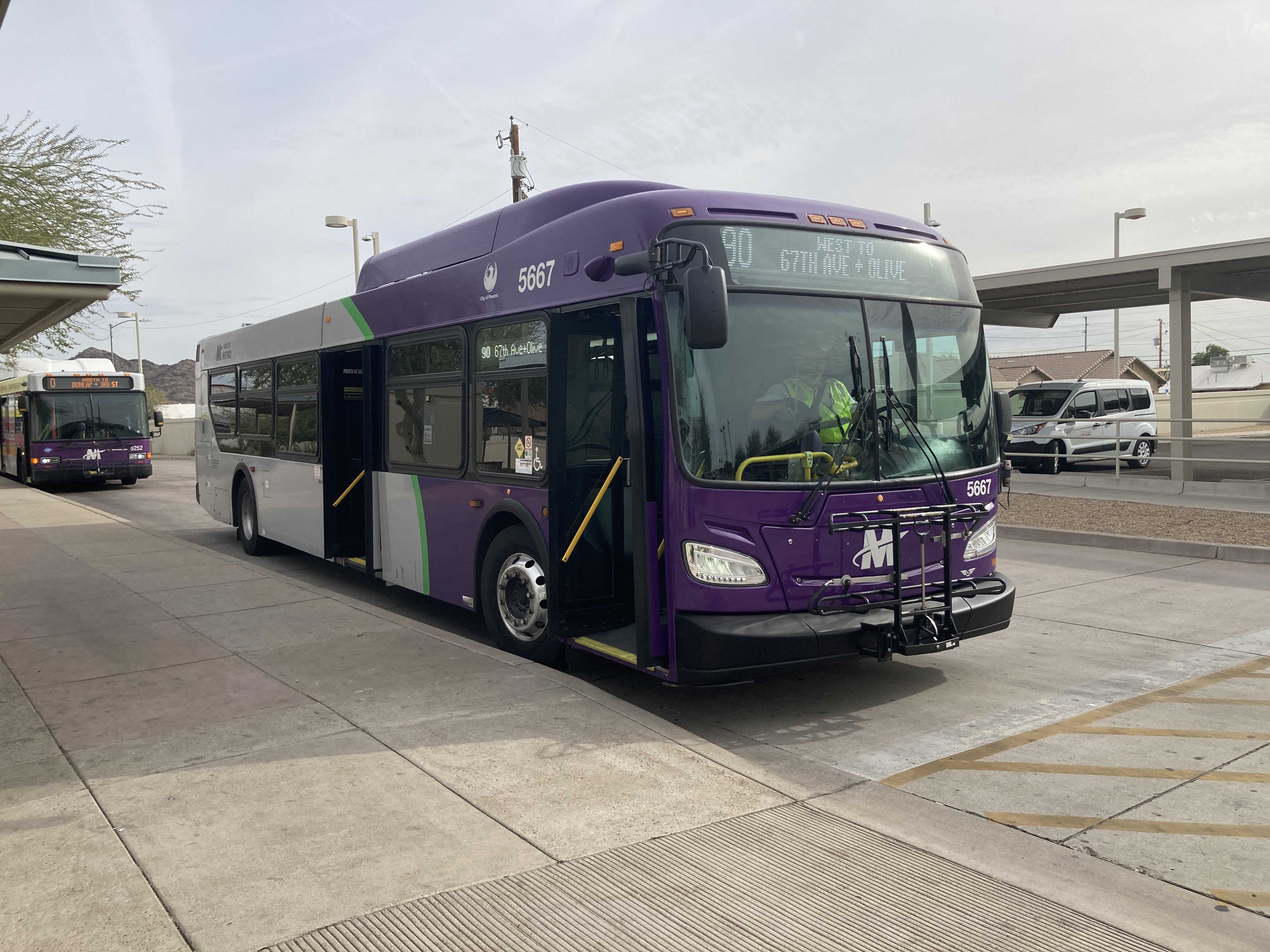 A gray and purple Valley Metro bus, with a green stripe, number 5667, at Sunnyslope Transit Center in Phoenix on route 90 to Olive Avenue and 67th Avenue