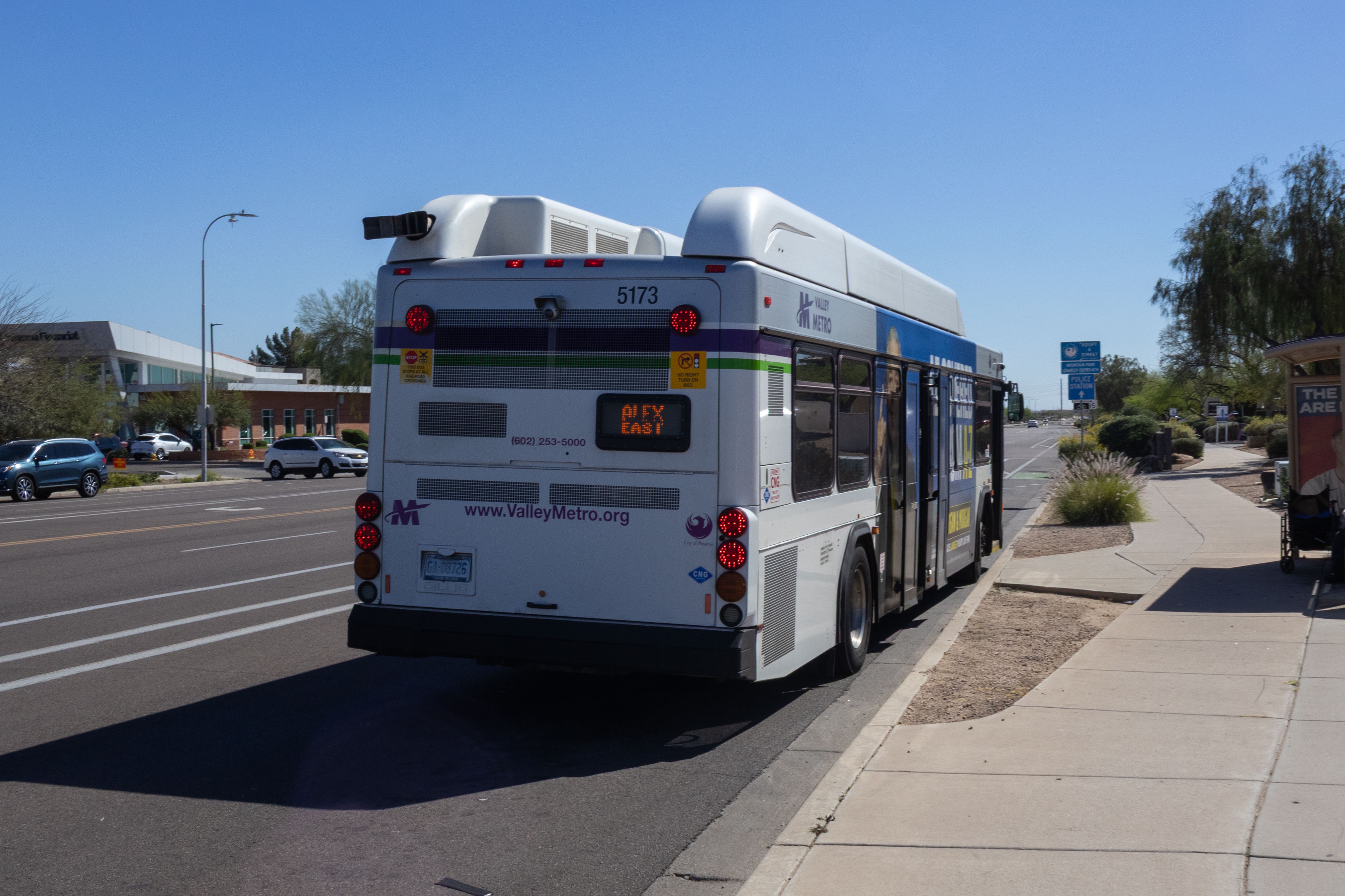 A white and gray Valley Metro bus, with purple and green accent colors, number 5173, traveling southbound on 48th Street in Phoenix on the ALEX route to 51st Street and Elliot Road