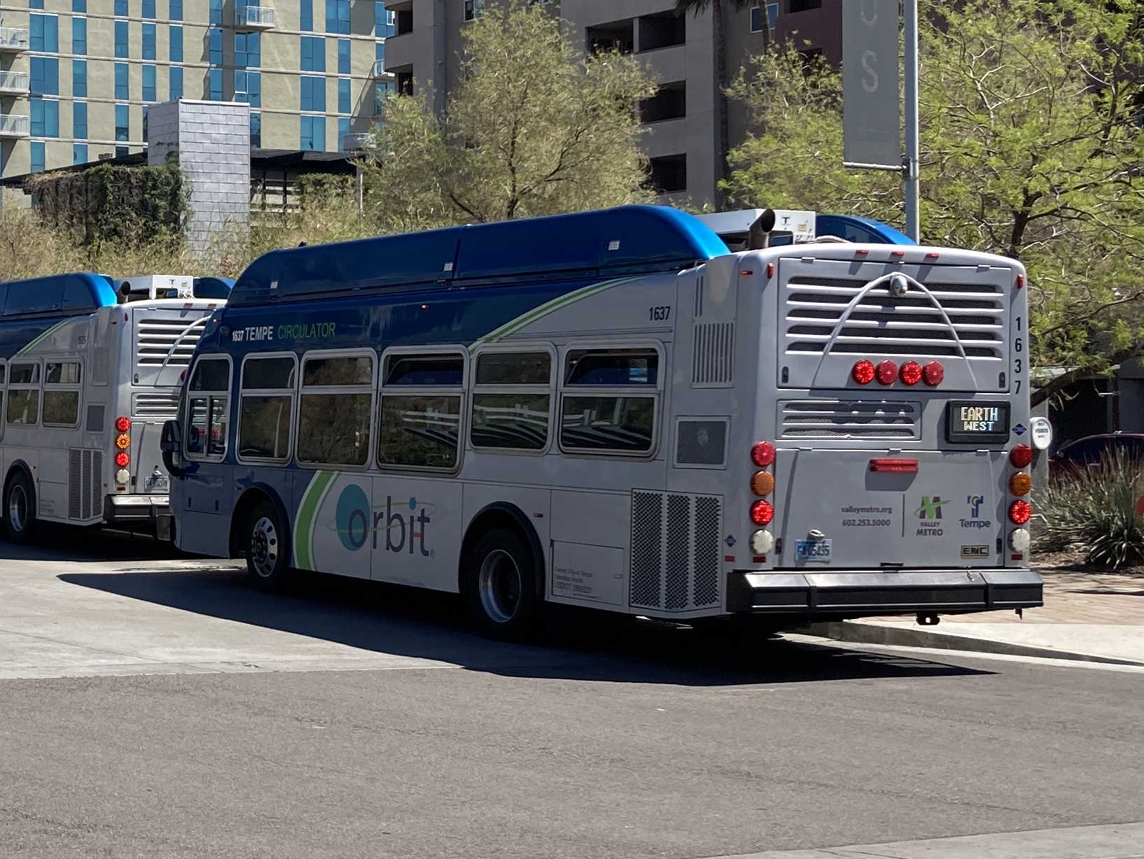 A gray and blue Orbit bus, with a green stripe, number 1637, at Tempe Transportation Center on the Earth route to Tempe Transportation Center