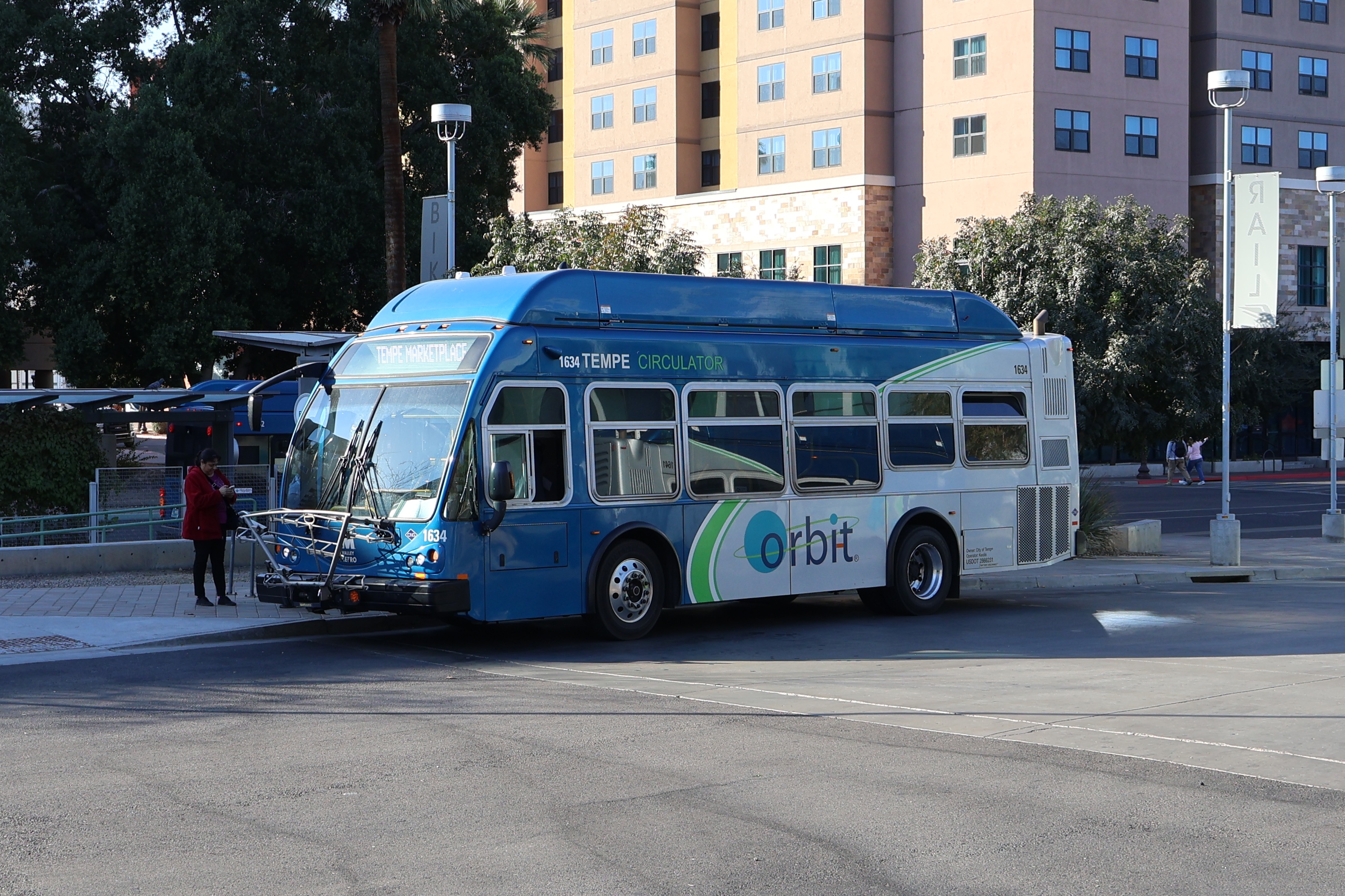 A gray and blue Orbit bus, with a green stripe, number 1634, at Tempe Transportation Center on the Earth route to Tempe Marketplace