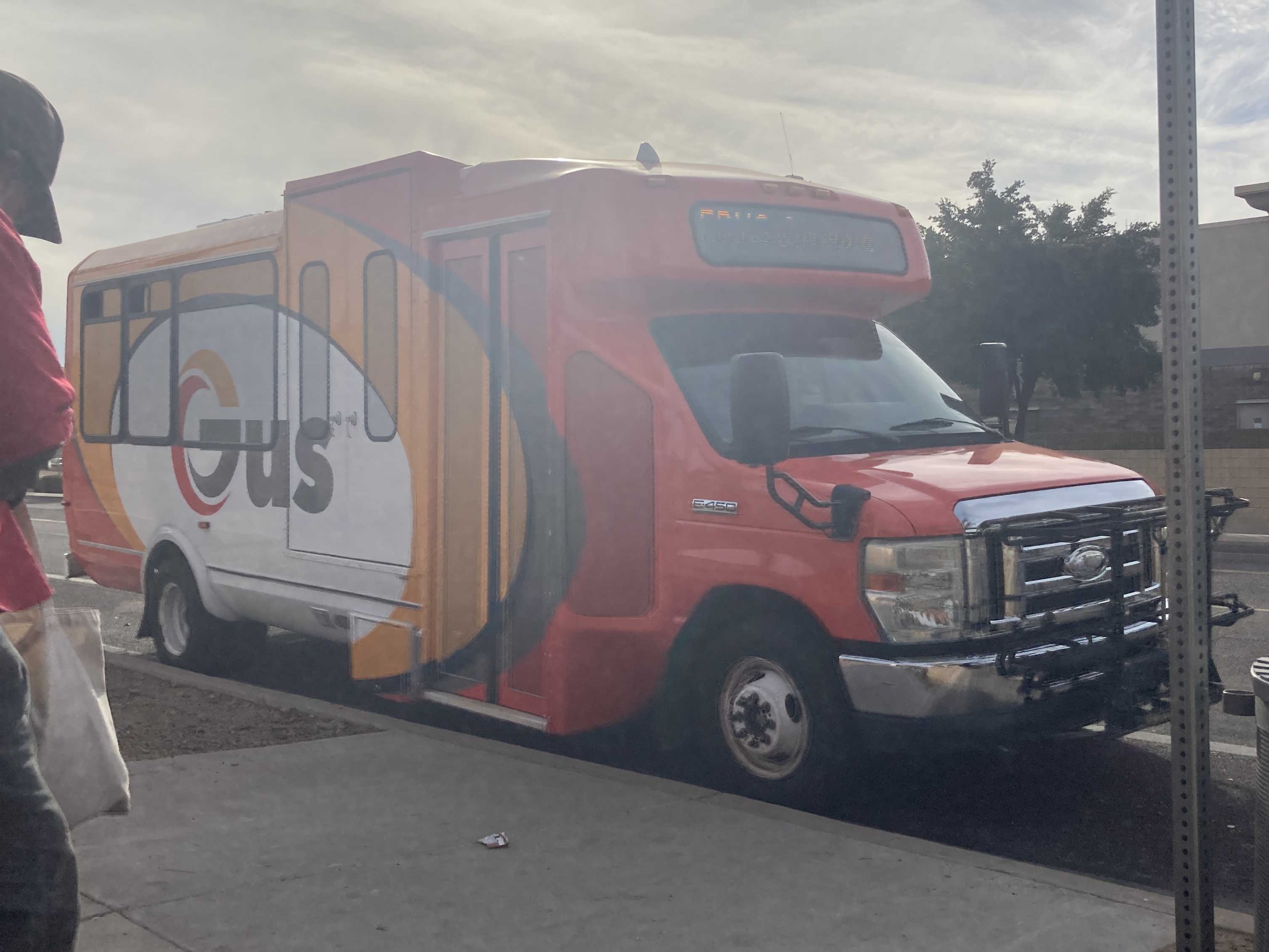 An orange, yellow, and white GUS minibus, unknown number, traveling northbound on 55th Avenue in Glendale on GUS 2 to Tanner Terrace