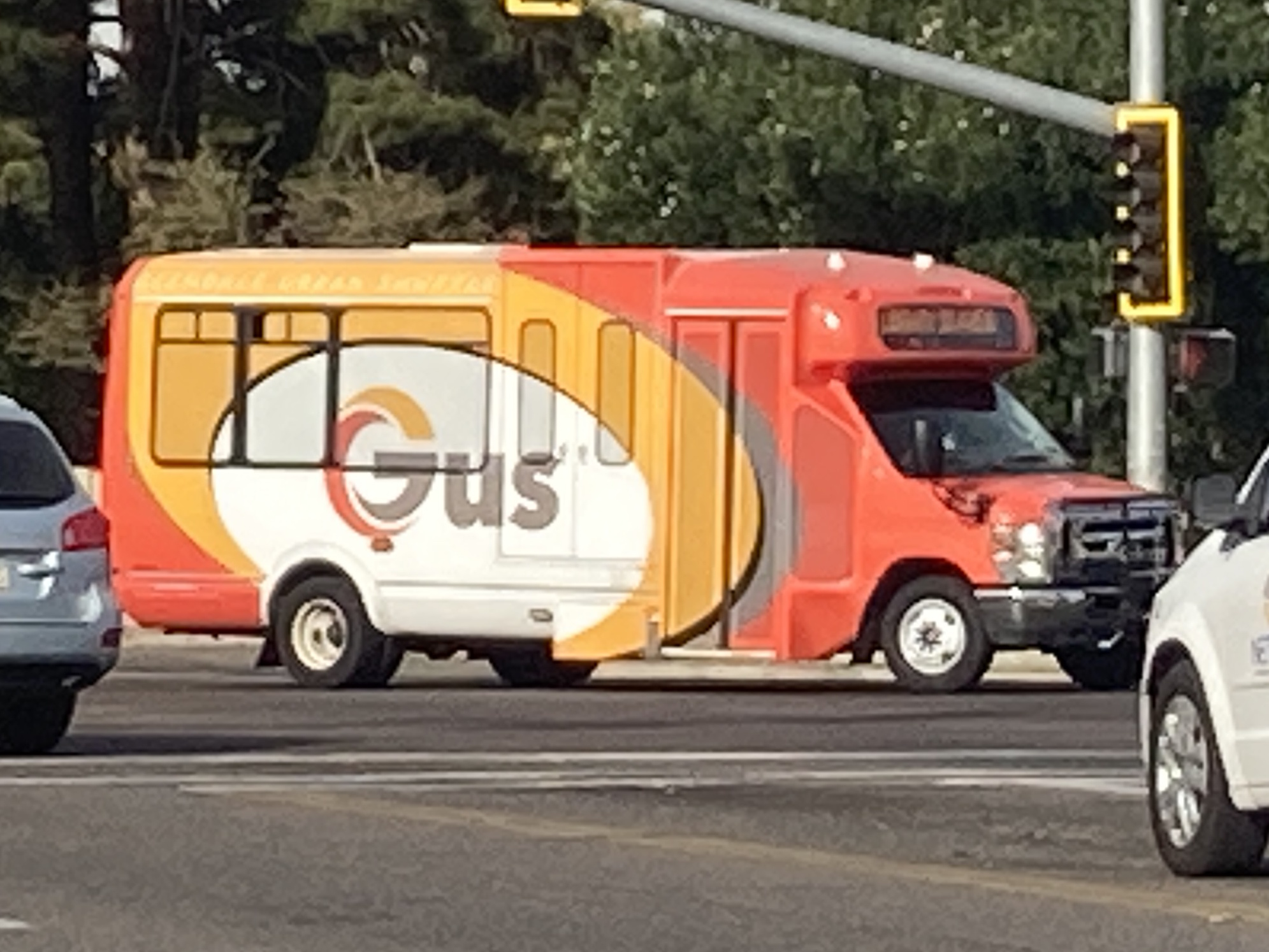 An orange, yellow, and white GUS minibus, unknown number, turning eastbound onto Northern Avenue in Glendale on GUS 3 to Manistee Manor