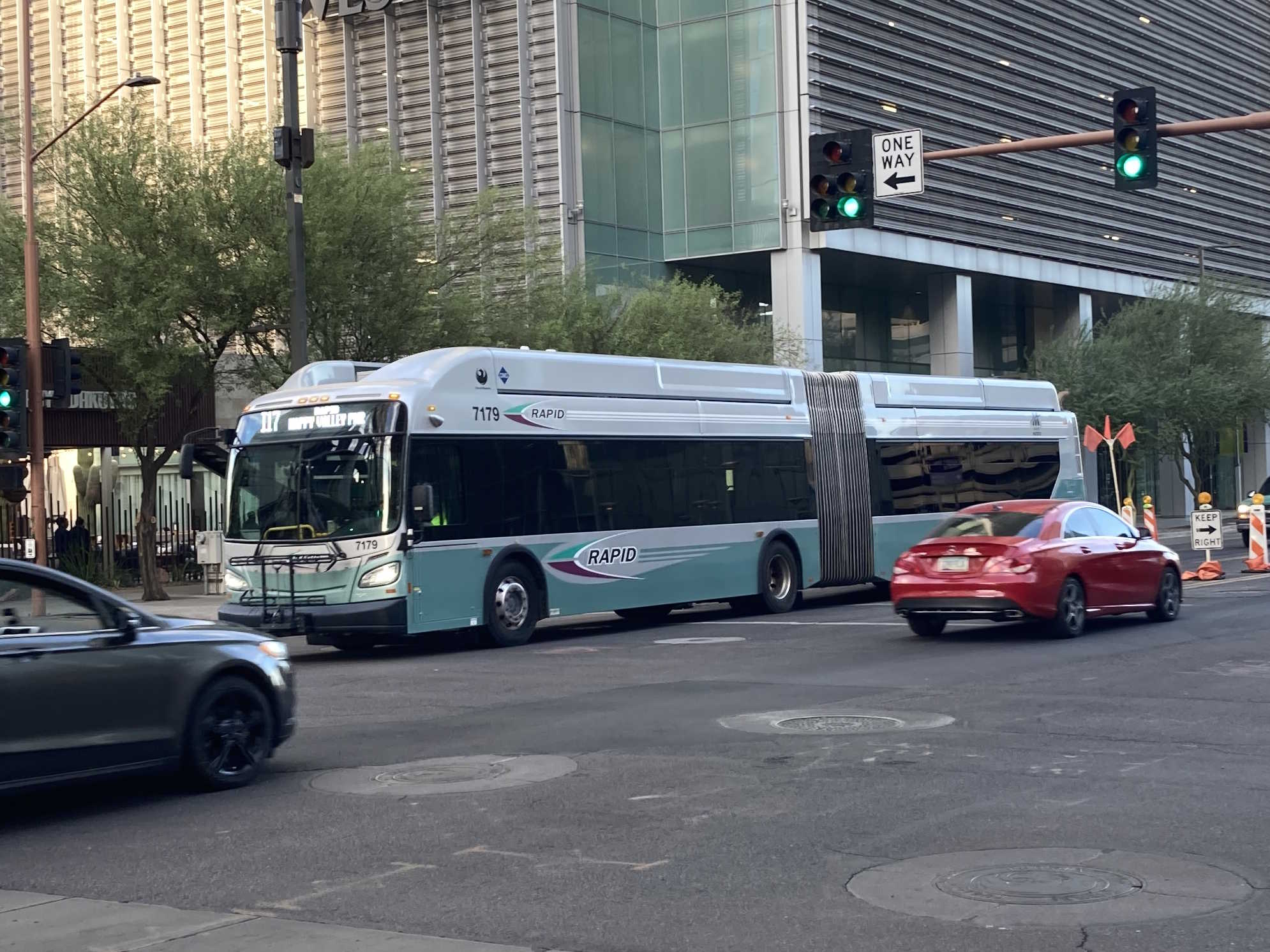 A silver and bluish-green articulated Valley Metro RAPID bus, number 7179, traveling westbound on Van Buren Street in Phoenix on the I-17 RAPID route to Happy Valley Park and Ride