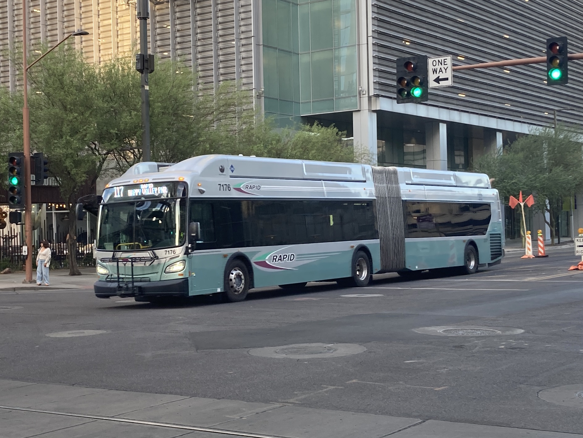 A silver and bluish-green articulated Valley Metro RAPID bus, number 7176, traveling westbound on Van Buren Street in Phoenix on the I-17 RAPID route to Happy Valley Park and Ride