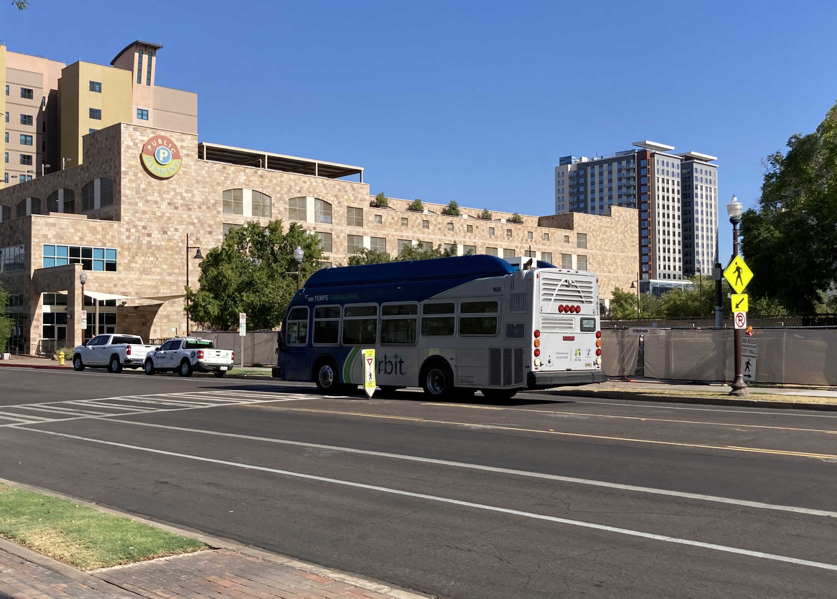 A gray and blue Orbit bus, with a green stripe, number 1605, traveling eastbound on 5th Street on the Jupiter route to Tempe Transportation Center