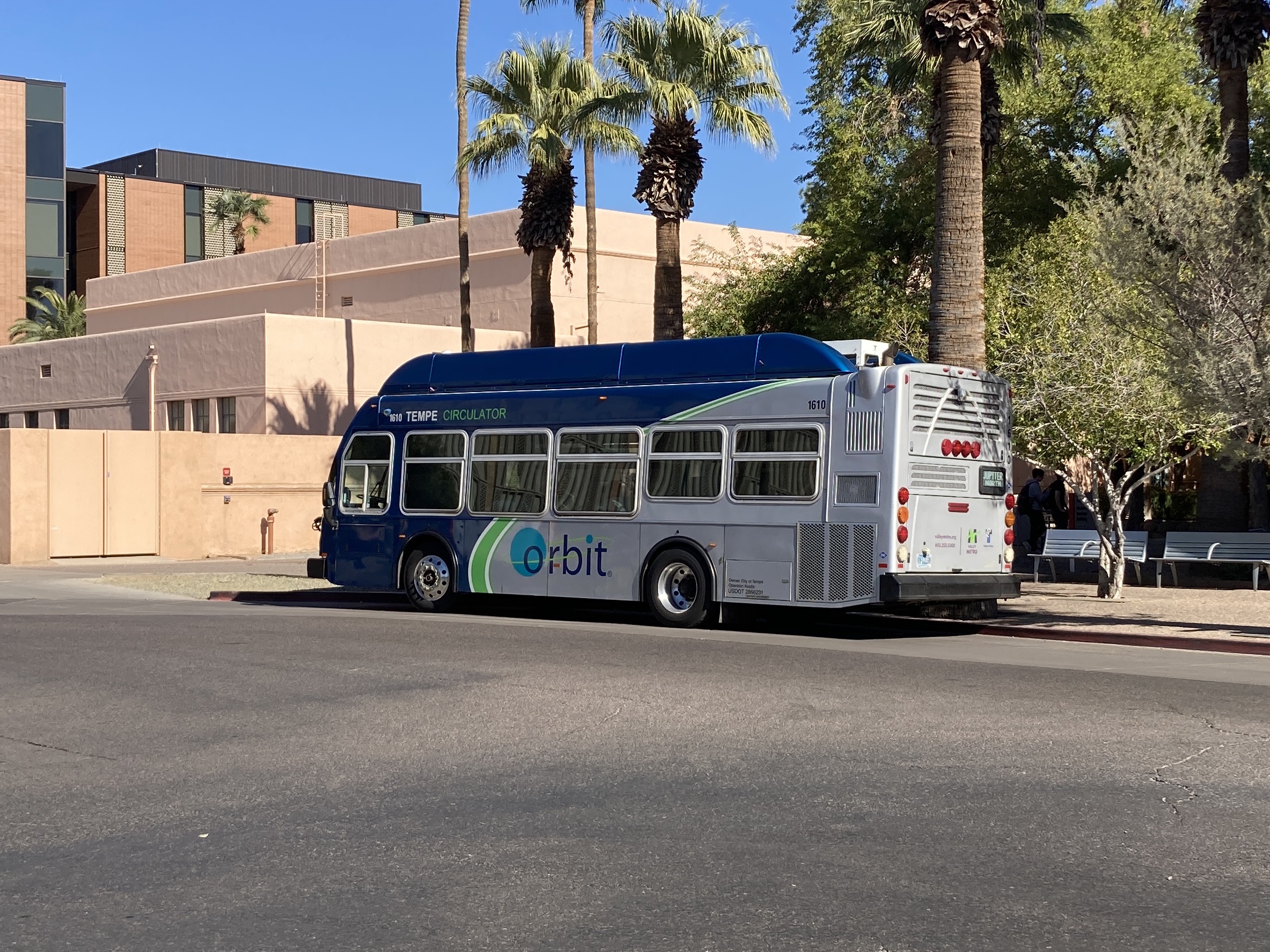 A gray and blue Orbit bus, with a green stripe, number 1610, traveling northbound on Forest Avenue on the Jupiter route to Tempe Transportation Center