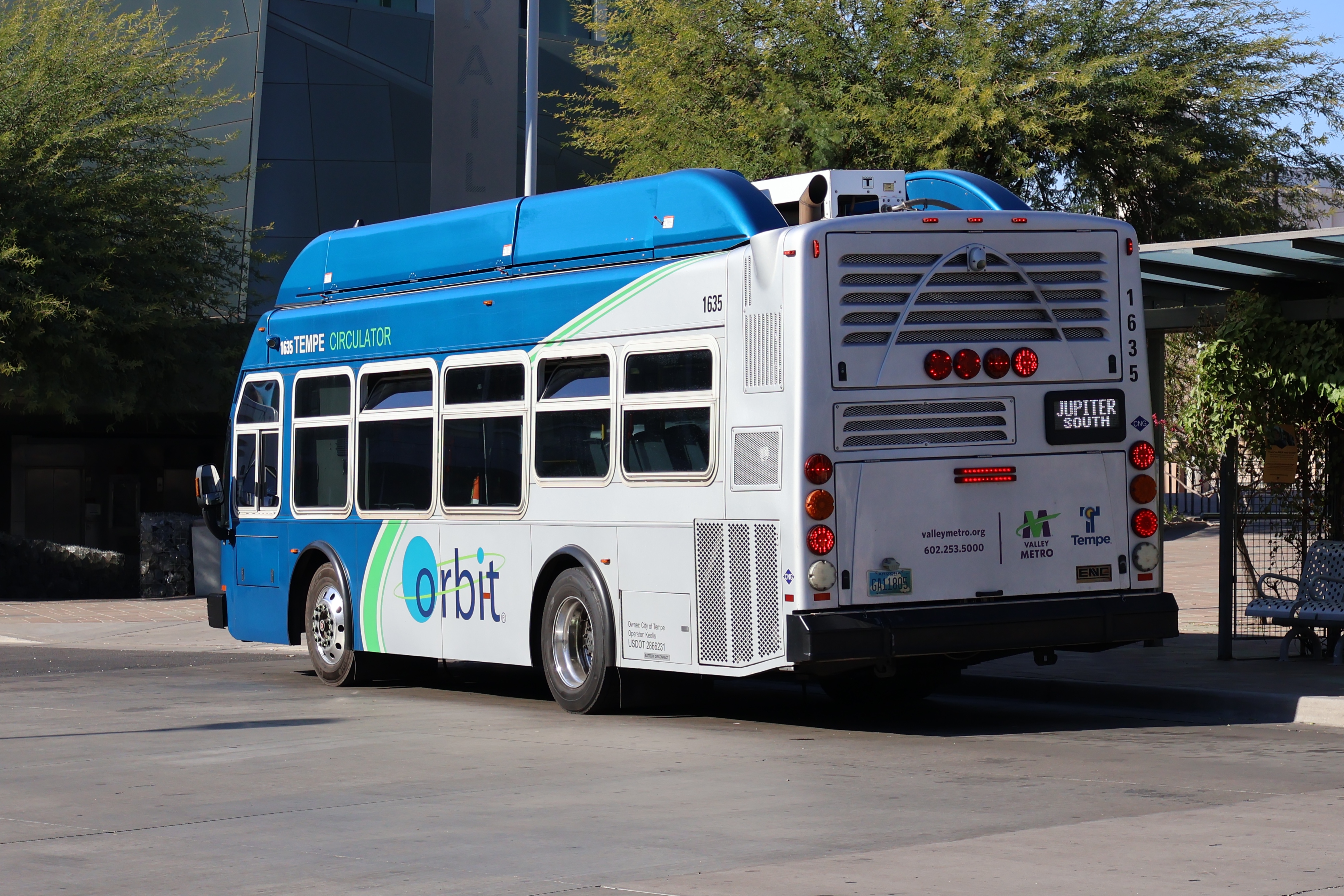 A gray and blue Orbit bus, with a green stripe, number 1635, at Tempe Transportation Center on the Jupiter route to McClintock High School