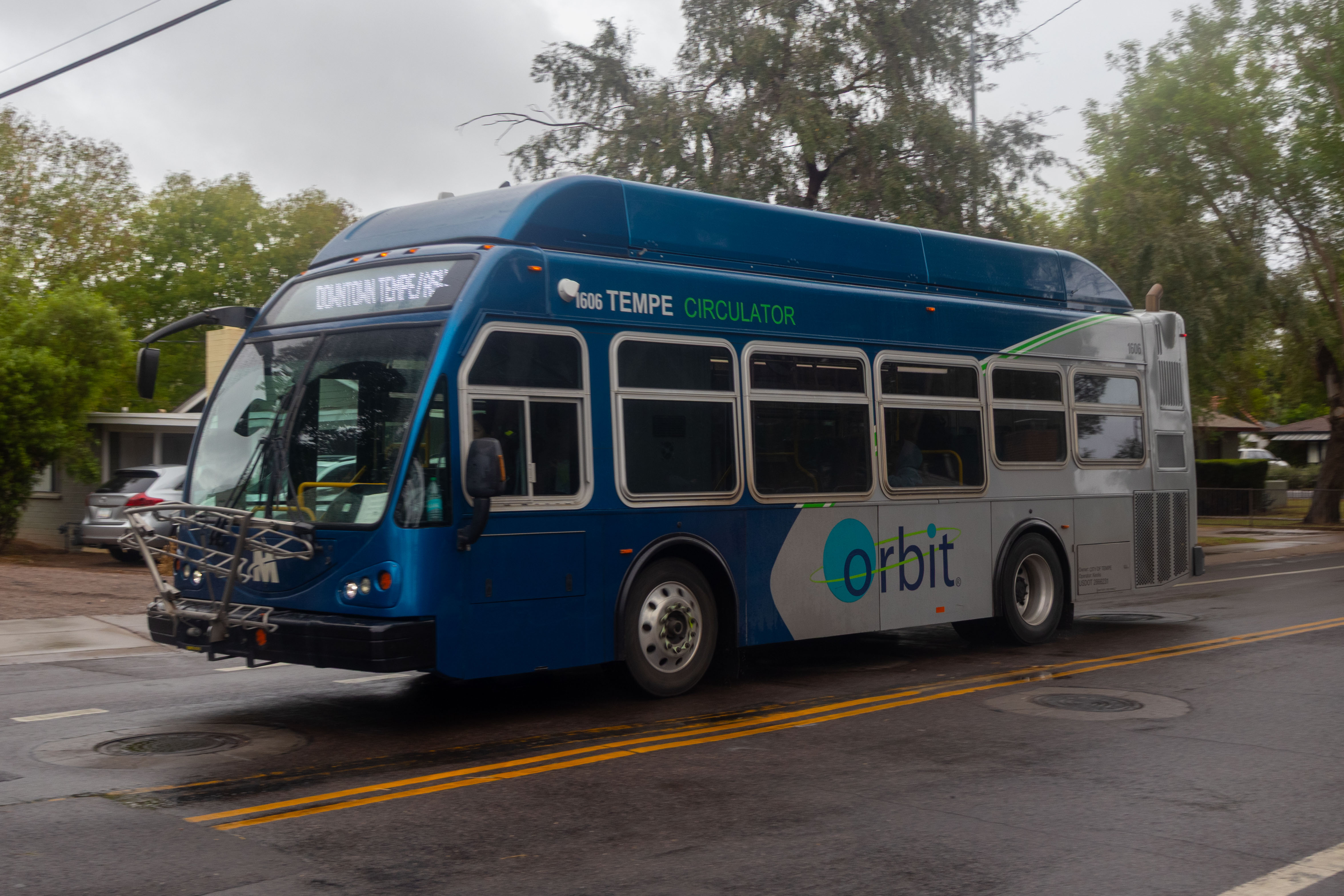 A gray and blue Orbit bus, with a green stripe, number 1606, traveling northbound on College Avenue on the Jupiter route to Tempe Transportation Center