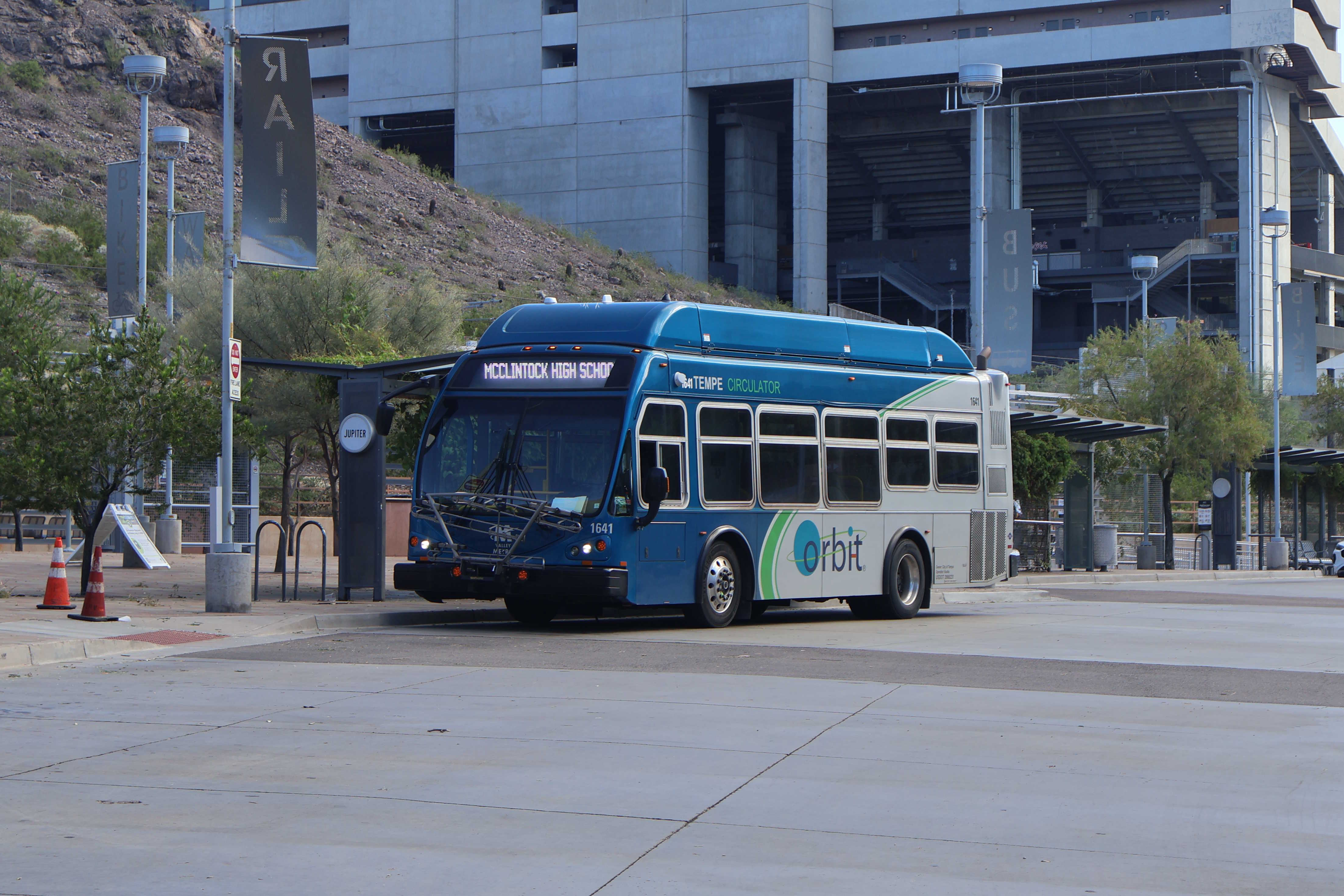 A gray and blue Orbit bus, with a green stripe, number 1641, at Tempe Transportation Center on the Jupiter route to McClintock High School