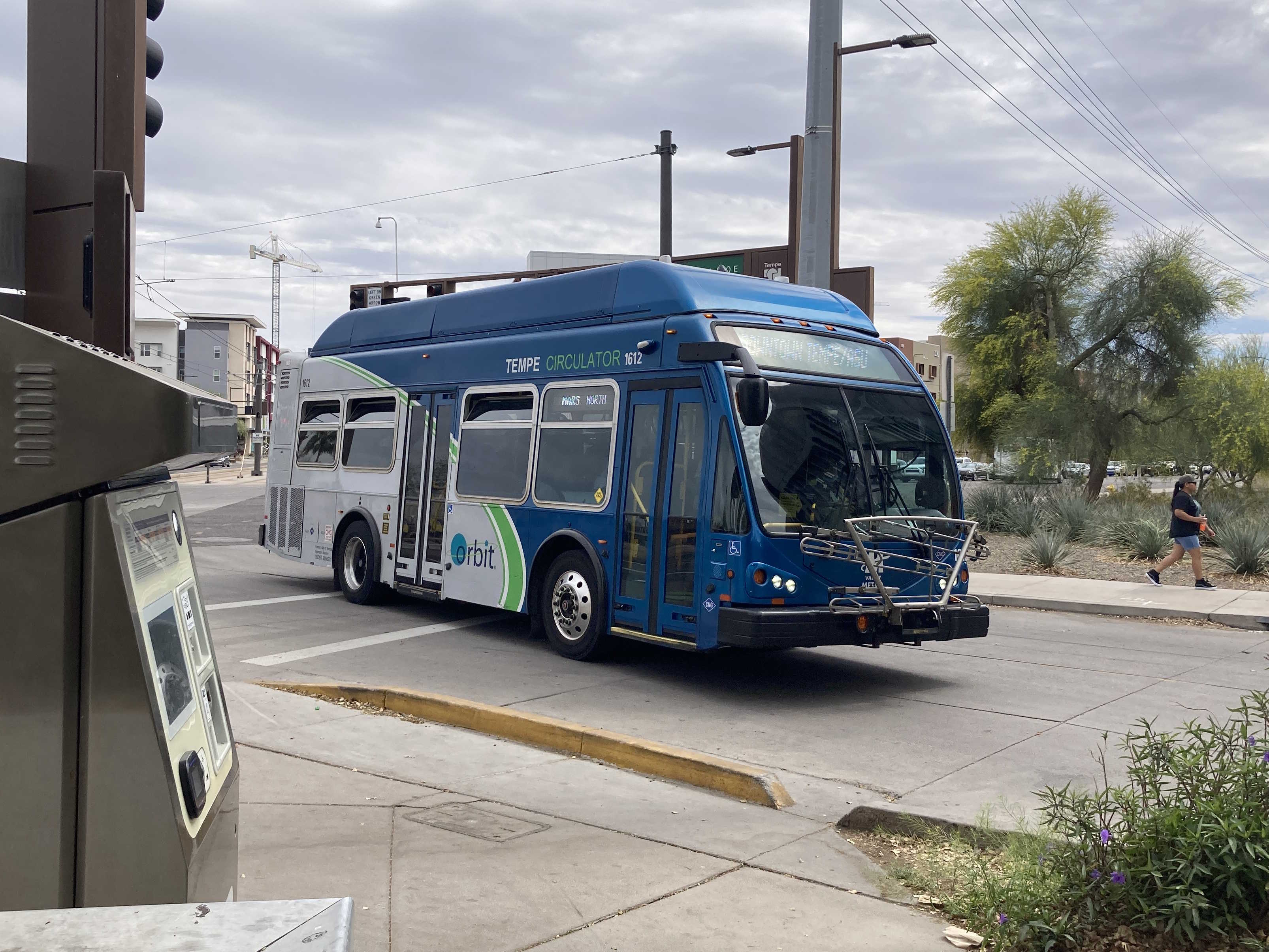 A gray and blue Orbit bus, with a green stripe, number 1612, at the University and Rural Transit Center on the Mars route to Tempe Transportation Center