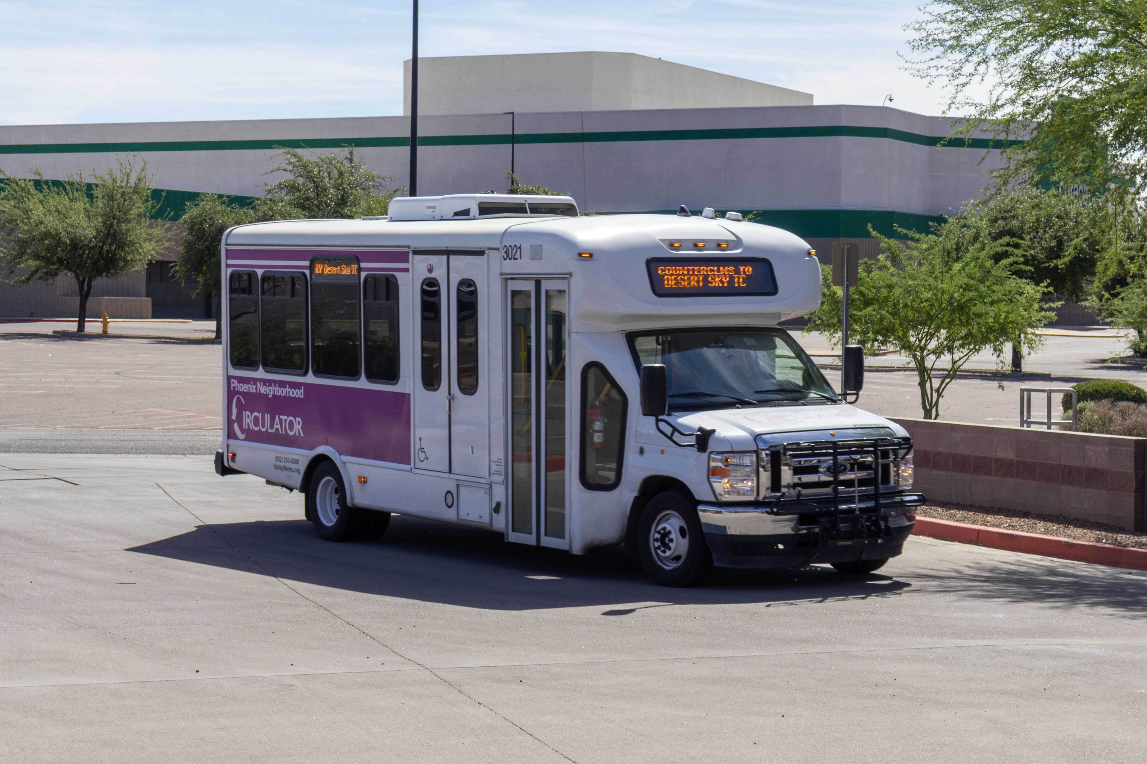 A white and purple Phoenix Neighborhood Circulator minibus, number 3021, at Desert Sky Transit Center in Phoenix on the MARY route to Desert Sky Transit Center