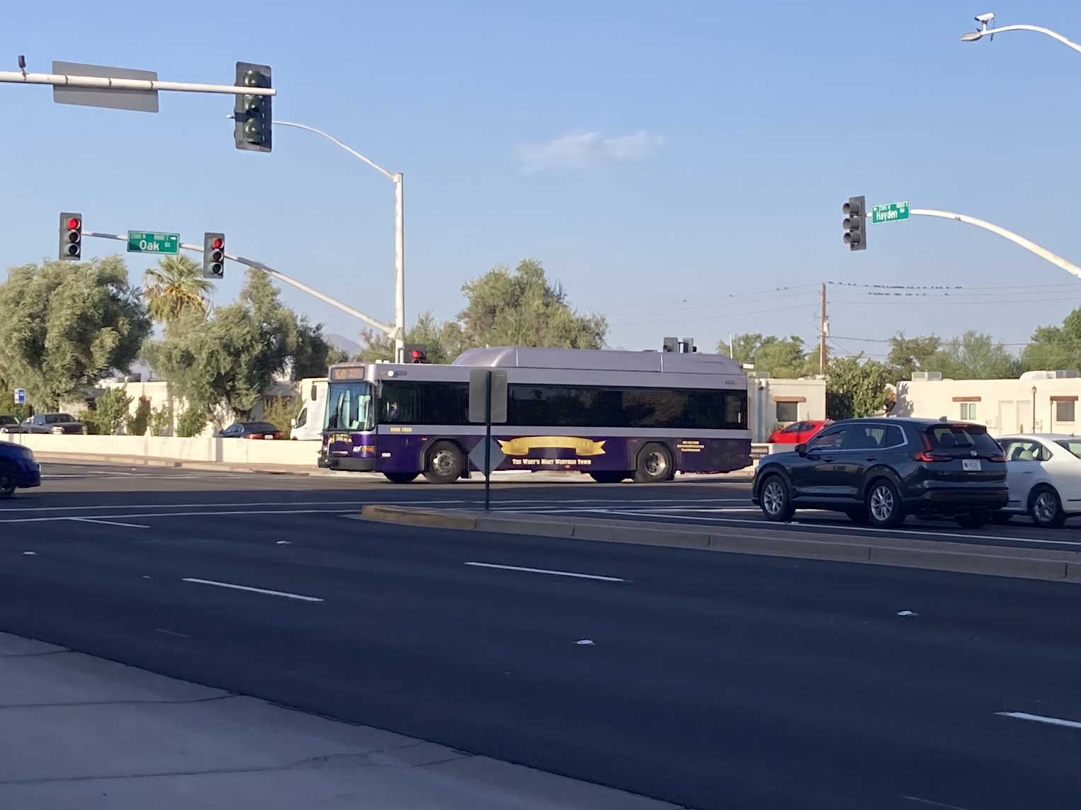 A purple and silver Scottsdale Trolley bus, number 4523, traveling westbound on Oak Street on the Miller/Hayden Trolley route to Mustang Transit Center