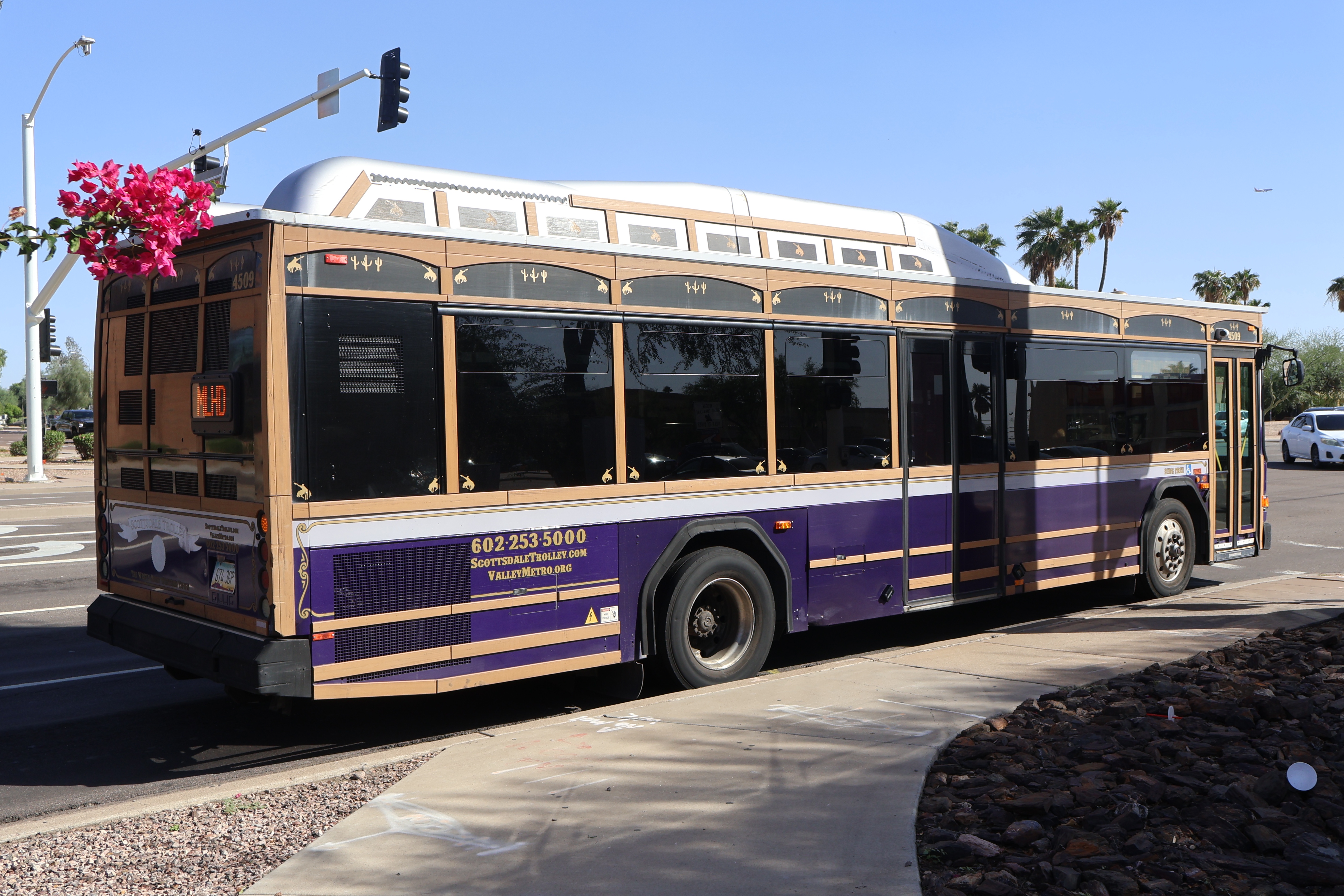 A purple, brown, and silver Scottsdale Trolley bus, number 4509, traveling southbound on Hayden Road on the Miller/Hayden Trolley route to Mustang Transit Center