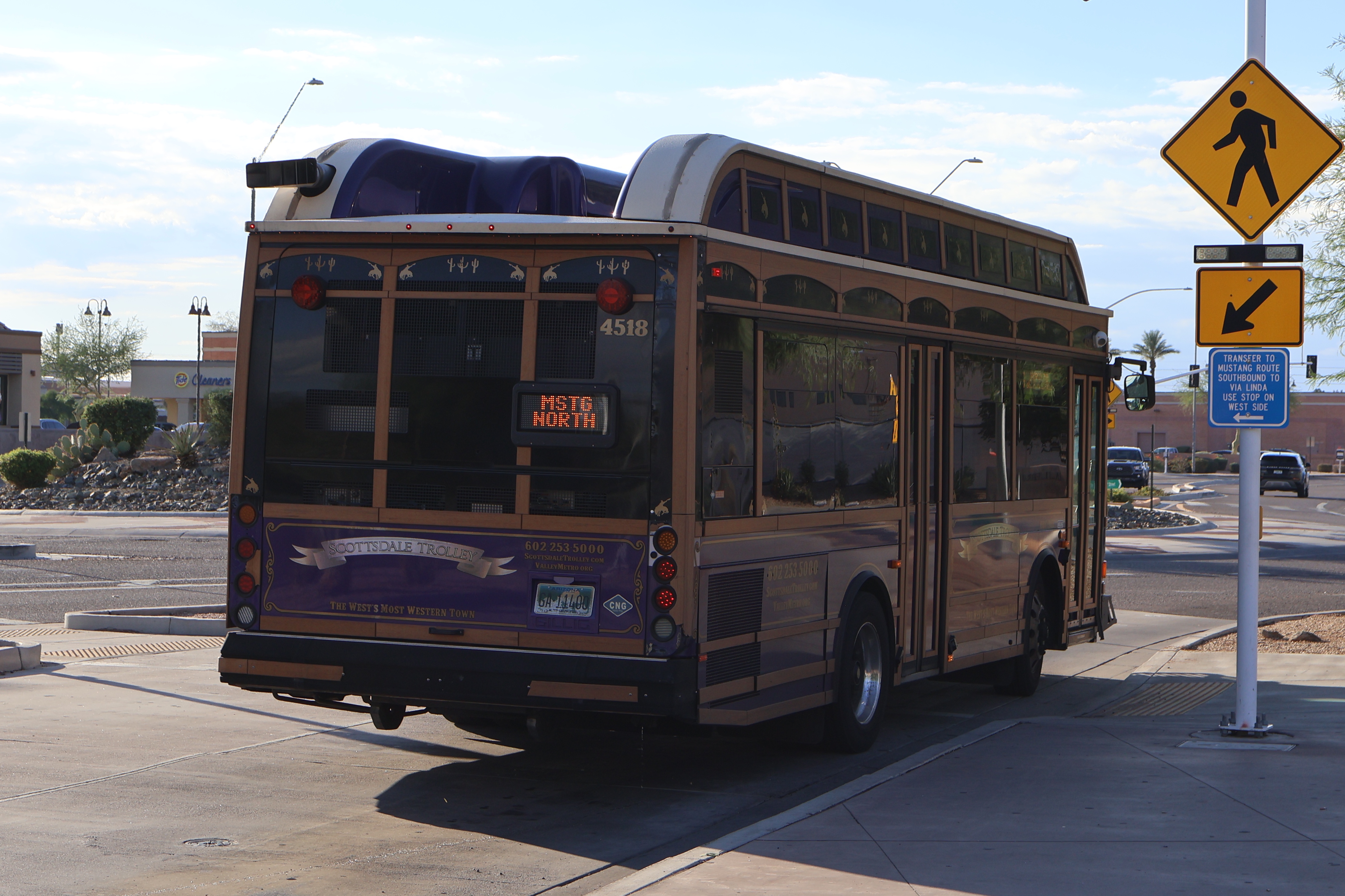 A purple, brown, and silver Scottsdale Trolley bus, number 4518, at Mustang Transit Center on the Mustang Trolley route to Northsight Boulevard and Raintree Drive